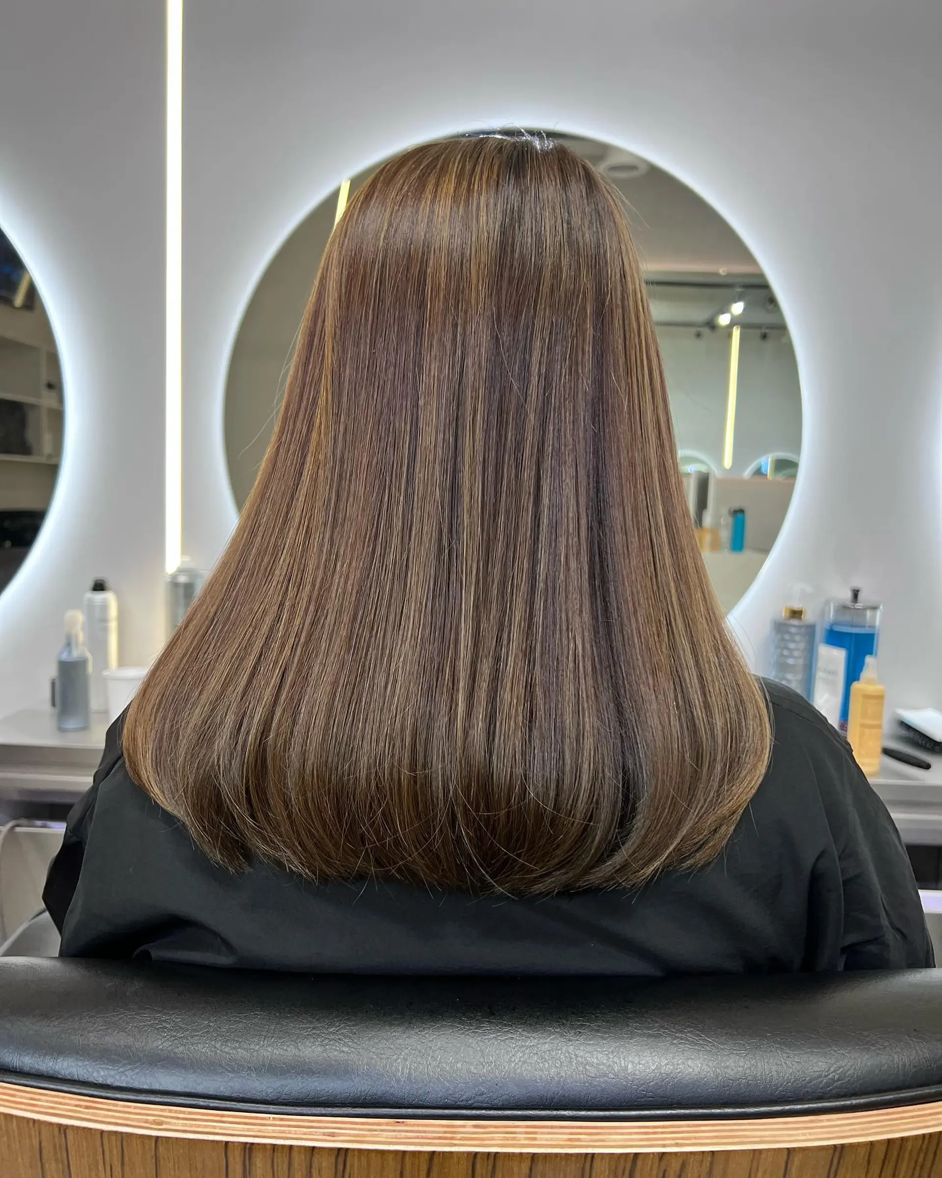 Long, straight hair with warm caramel highlights. 1