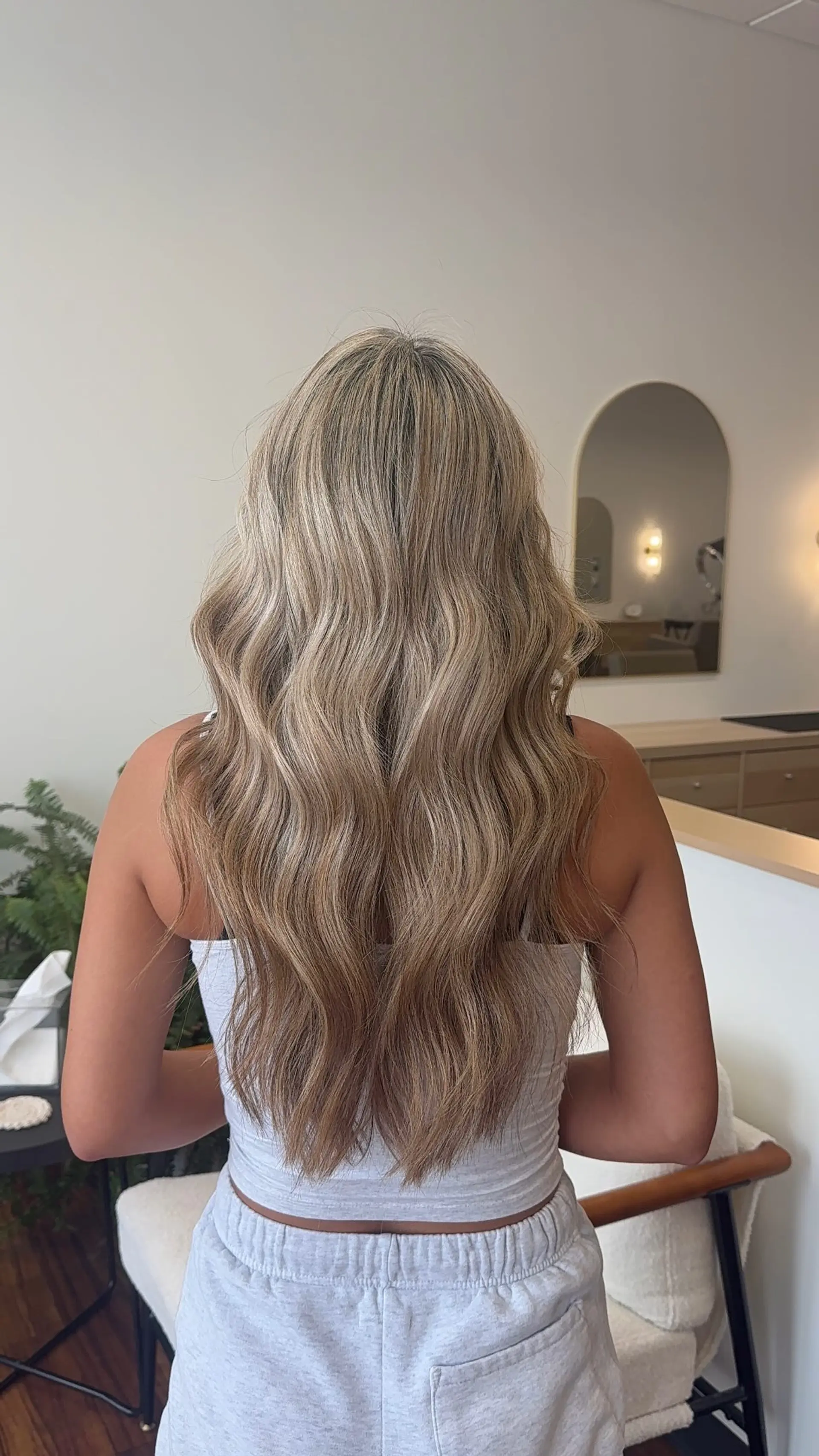 Long hair featuring dimensional blonde color styled in soft, relaxed waves. 1