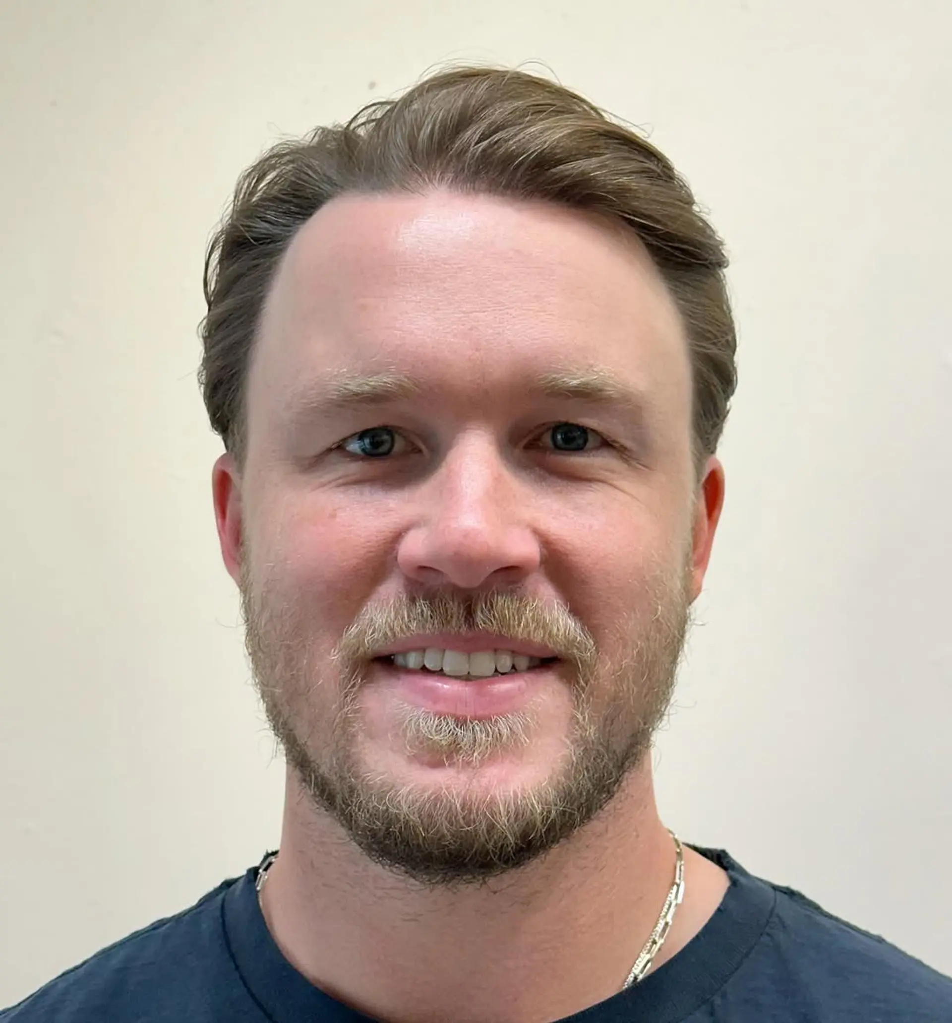 Classic gentleman's sweep with light brown wavy hair, featuring a natural side part and tapered sides for a polished look. 1