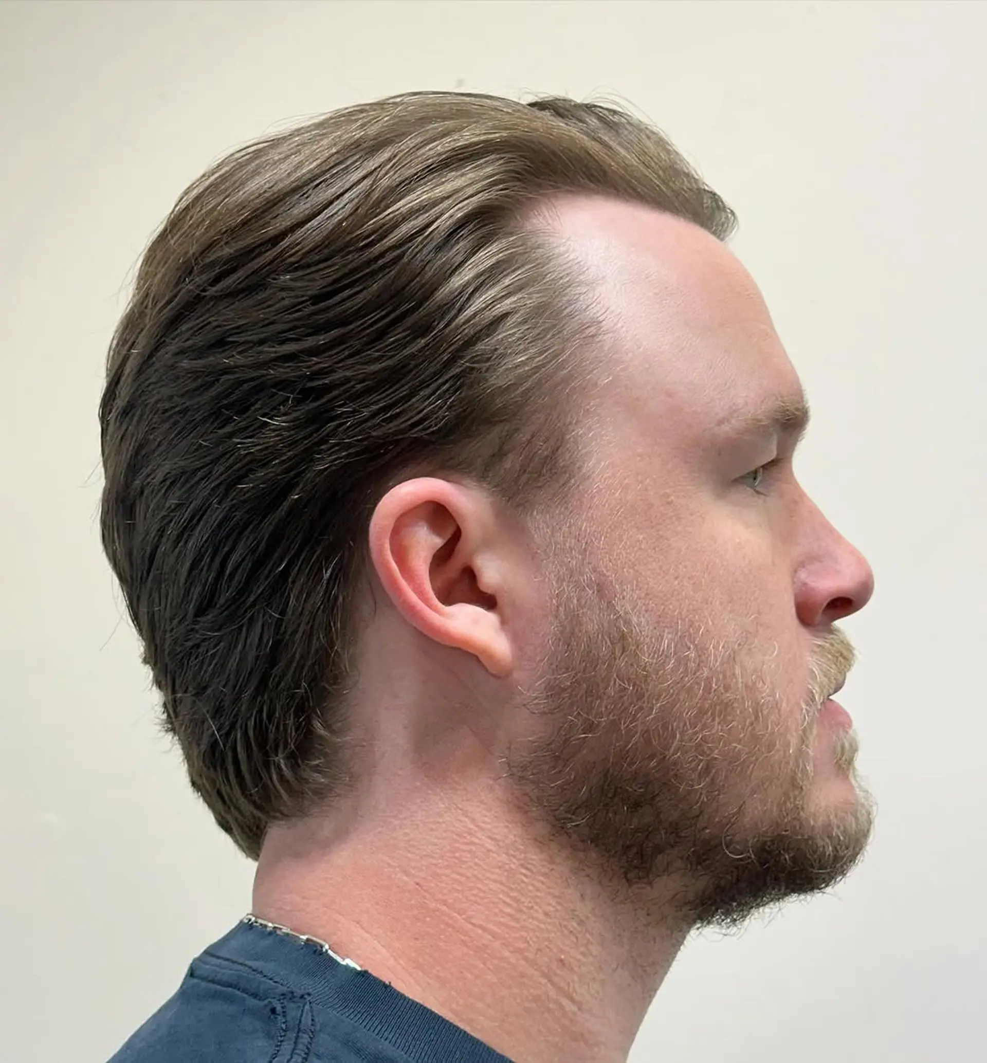 Classic gentleman's sweep with light brown wavy hair, featuring a natural side part and tapered sides for a polished look. 2