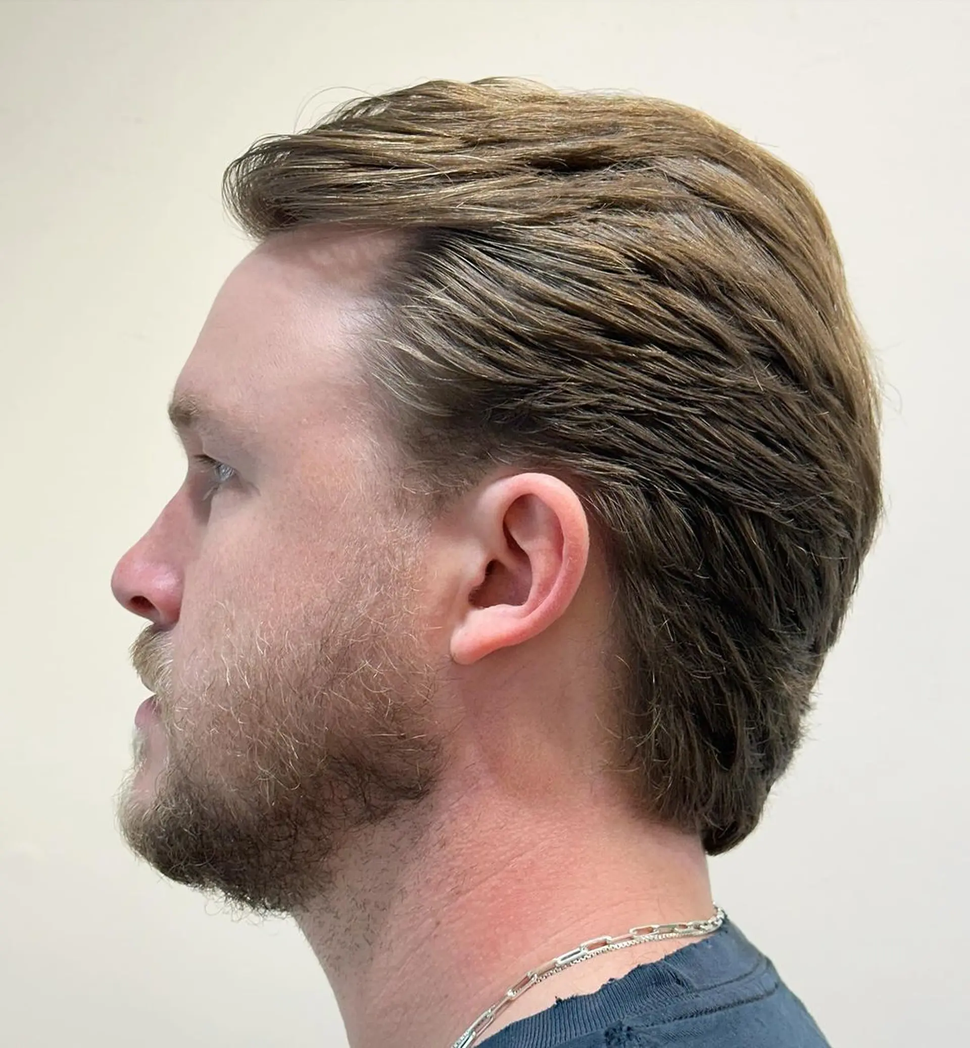 Classic gentleman's sweep with light brown wavy hair, featuring a natural side part and tapered sides for a polished look. 3