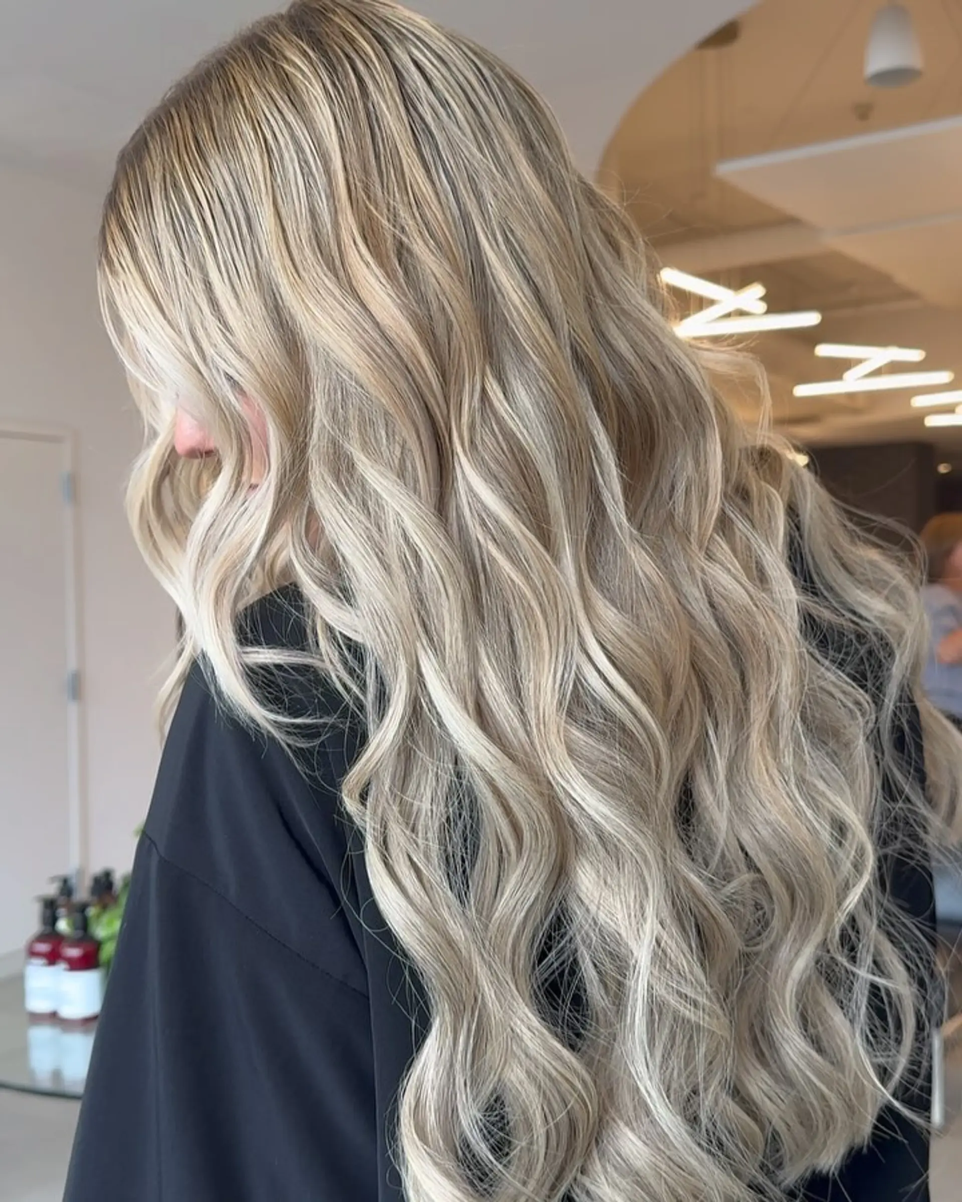 Extra-long dimensional ash blonde hair styled into full, flowing loose waves. 1