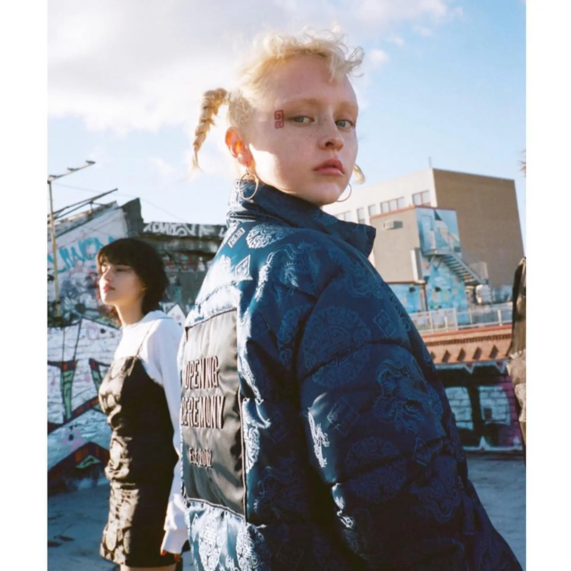 Two loose braids starting from the top and extending to the nape of the neck, featuring a wavy texture and blonde color. Style by @takeohair for OPENING CEREMONY x X-large x X-girl  2