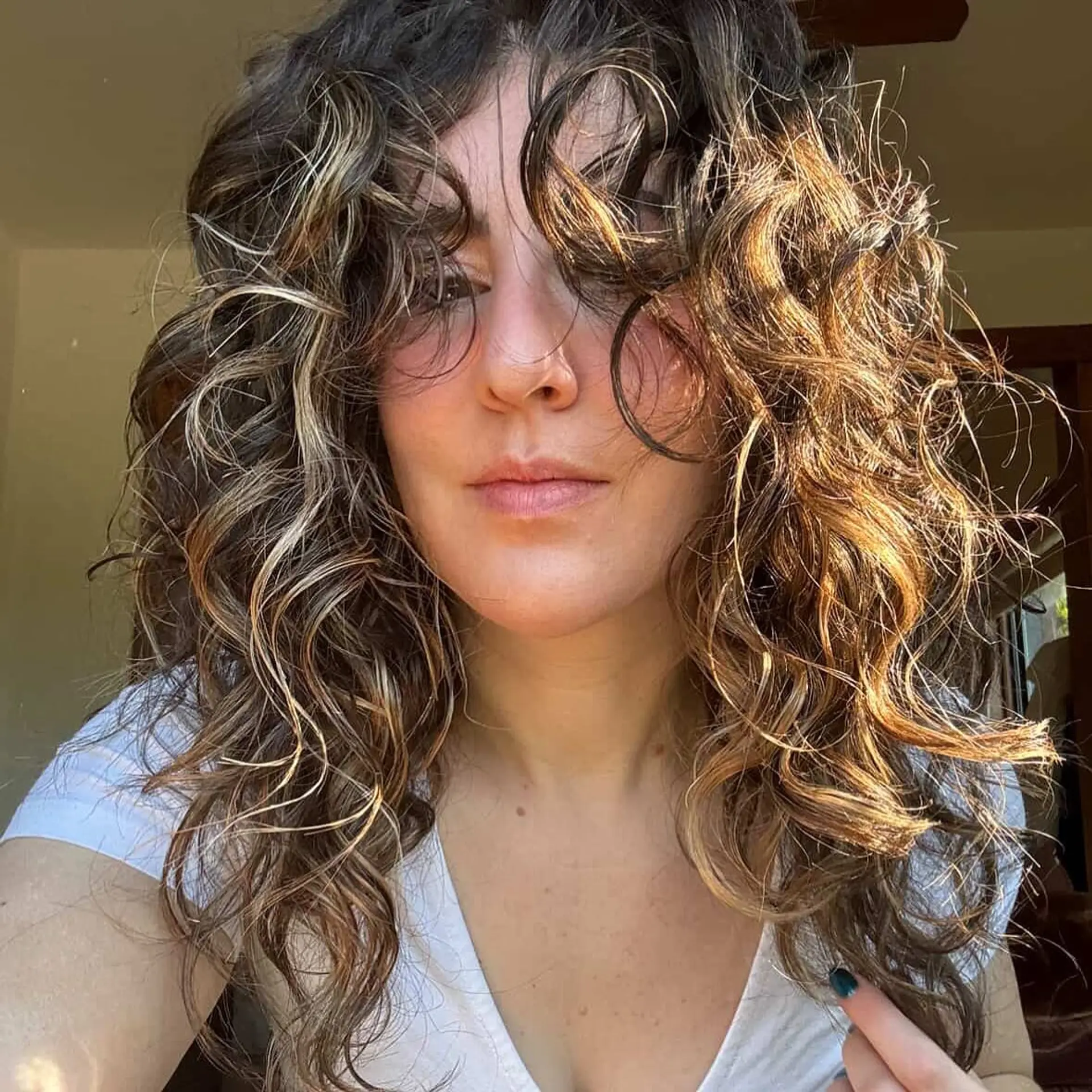 A layered curly hairstyle with a bronde balayage. 1