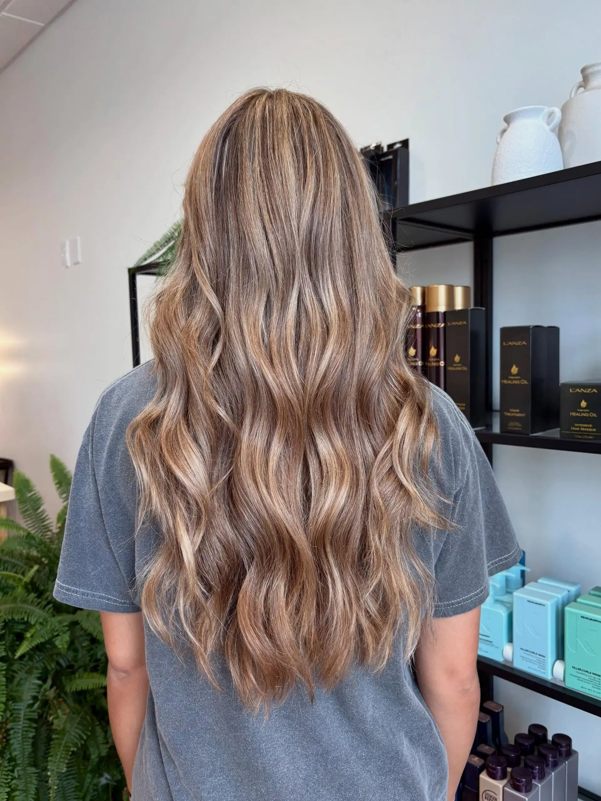Long dimensional bronde hair styled with soft, cascading loose waves. 1