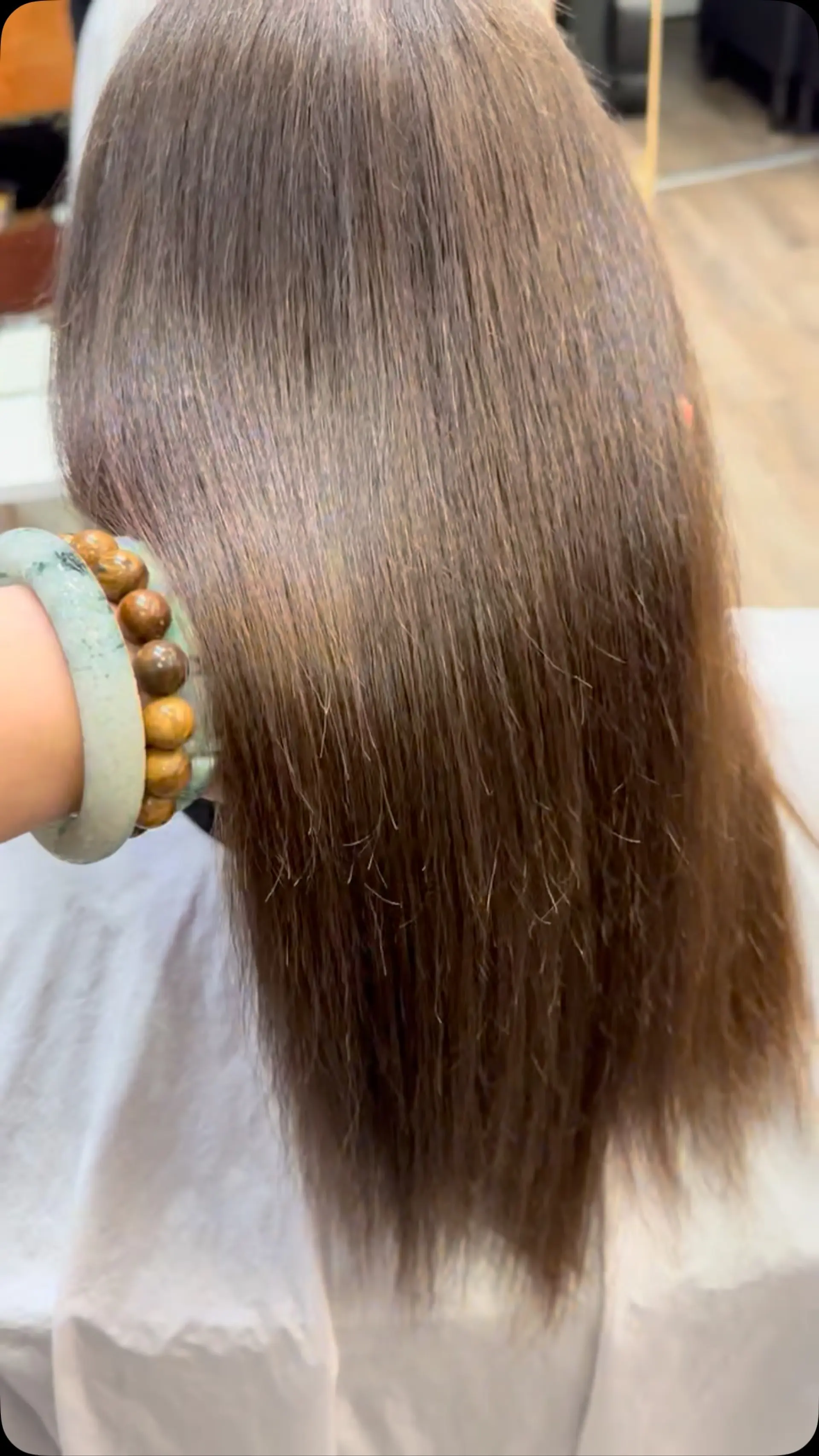 Smooth, glossy brunette hair styled straight with a sleek, frizz-free finish. 1