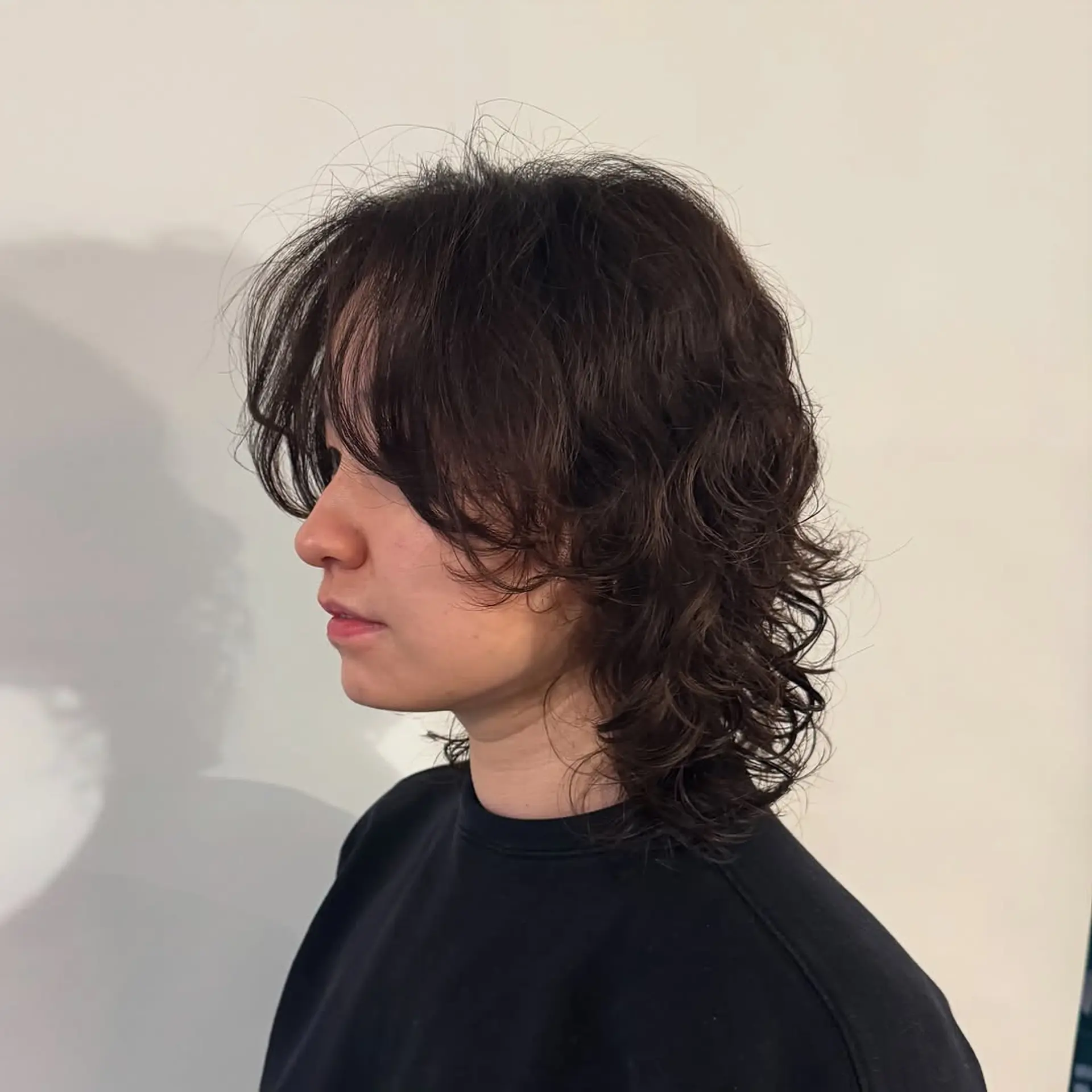 A layered, medium-length shag cut characterized by textured, piecey layers throughout and face-framing curtain bangs that blend into a voluminous, wavy silhouette. 1