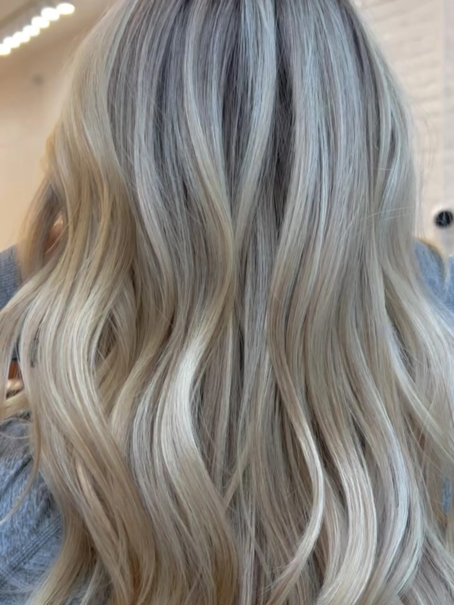 Long cool-toned blonde hair featuring multi-dimensional highlights styled in soft, loose waves. 1