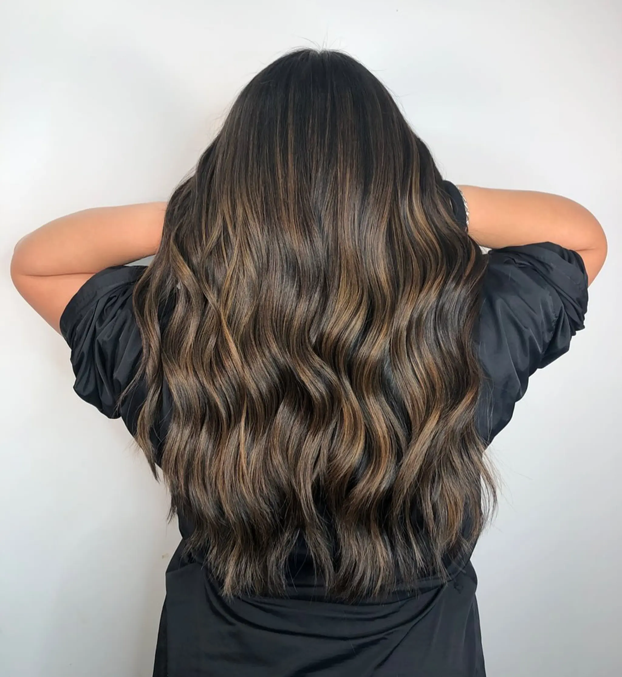 Very long, wavy hair with light brown highlights in dark brown base, featuring natural waves and long layers with a glossy finish.
Stylist - @xcellent_jason
