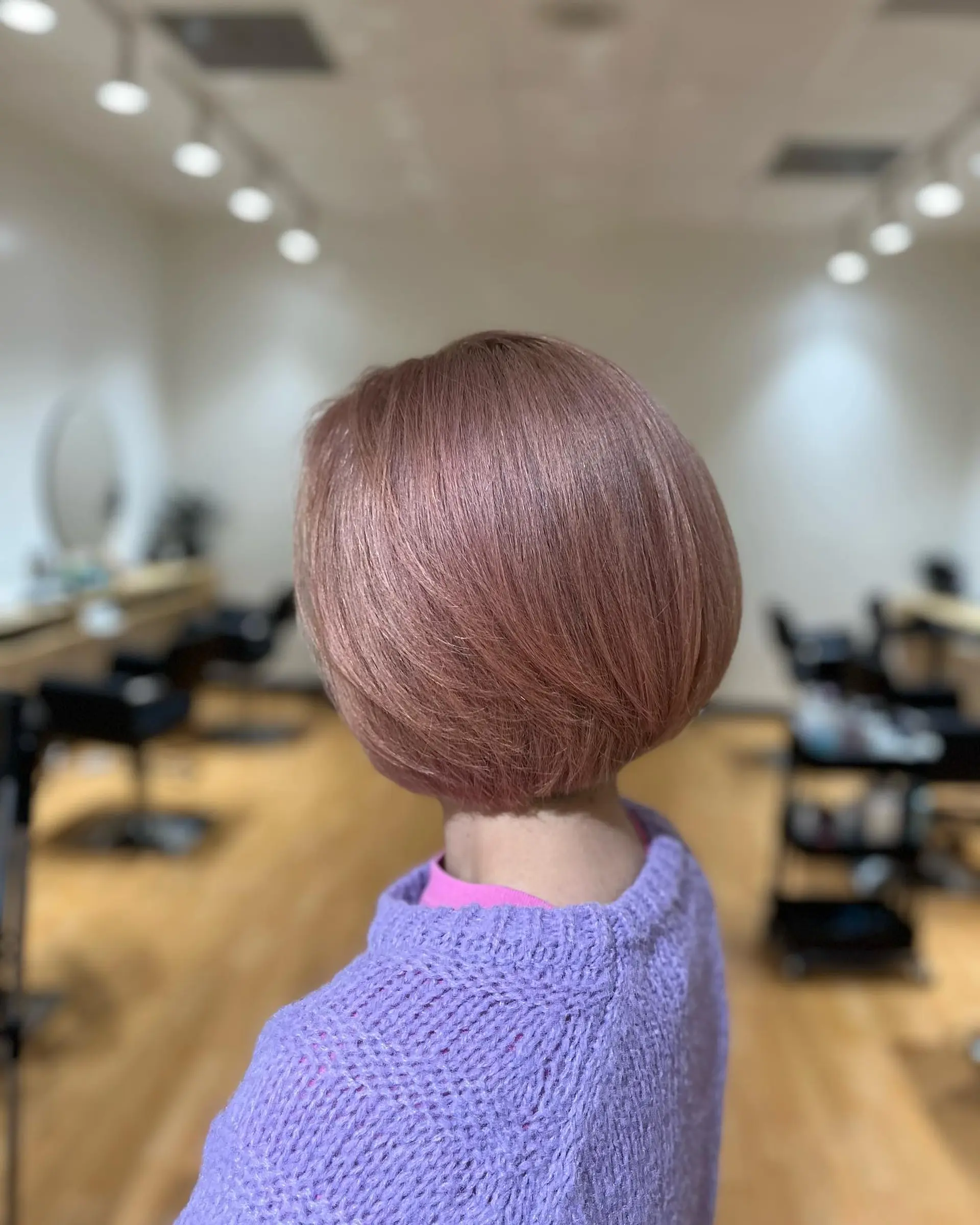 A sleek, rounded short bob styled with a smooth inward curve, colored in a pastel pink beige hue. 1
