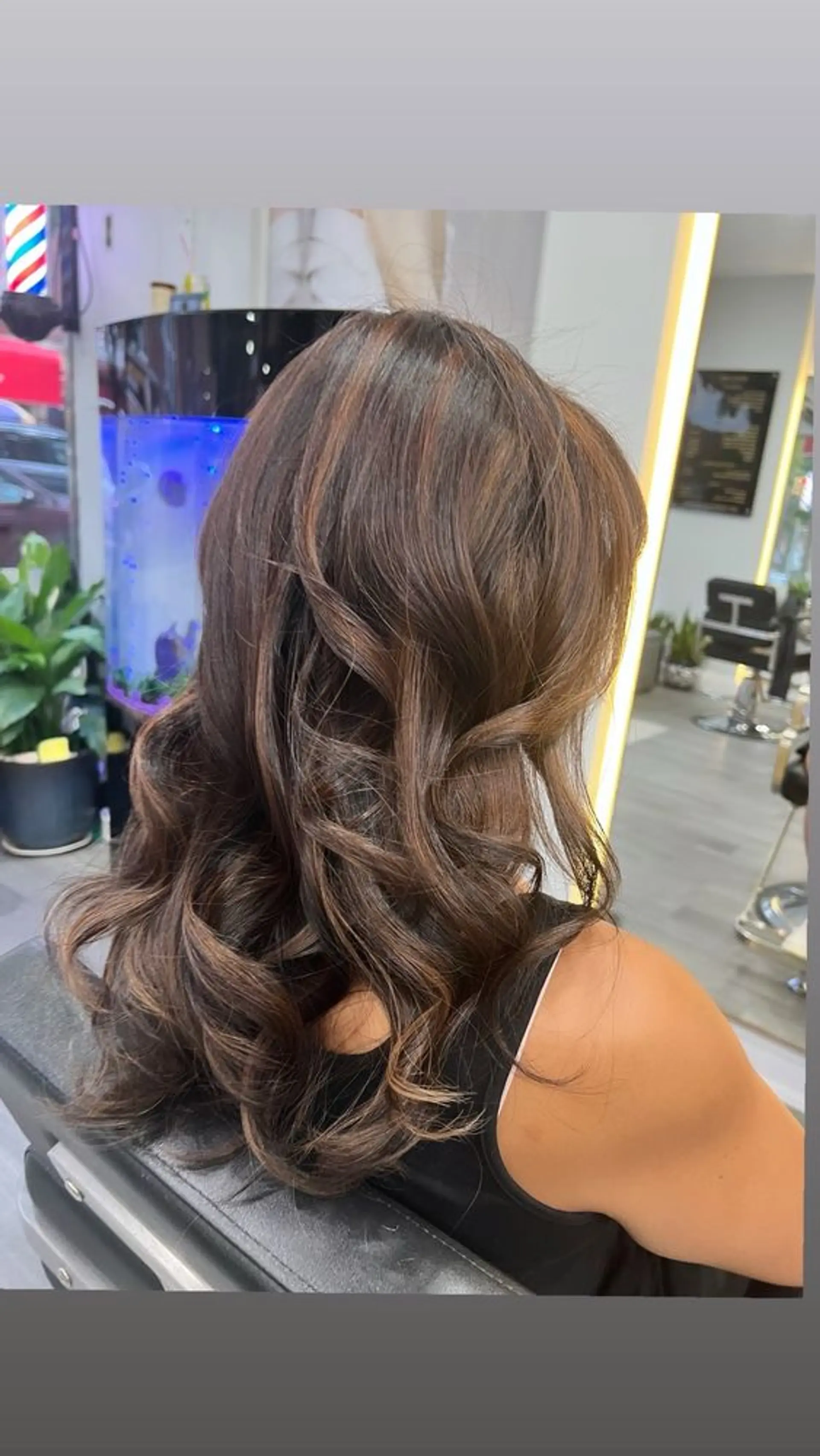 A layered, medium-length hairstyle with soft waves and caramel highlights. 1