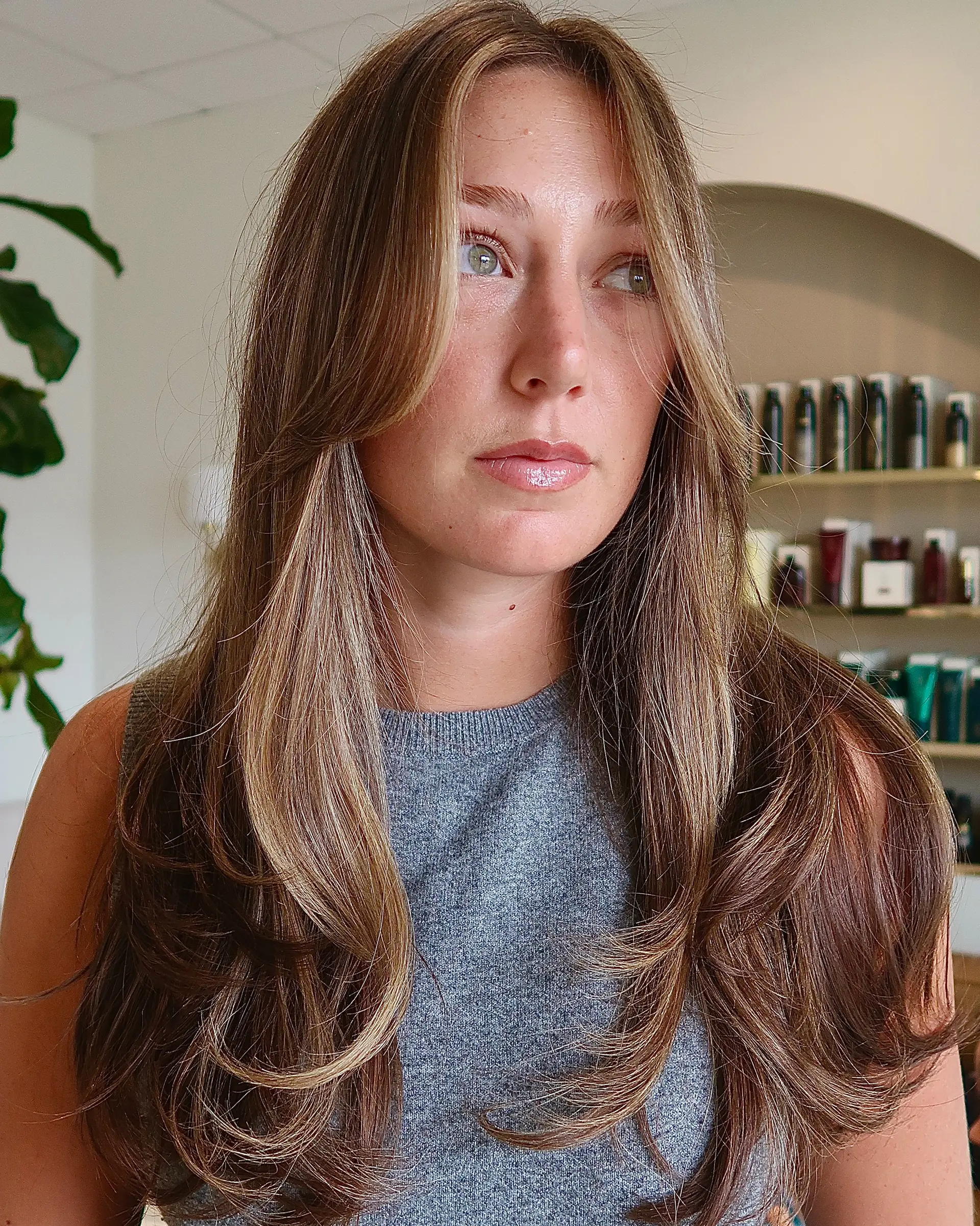 Long layered haircut featuring face-framing curtain bangs and a bouncy blowout with curled ends. 1