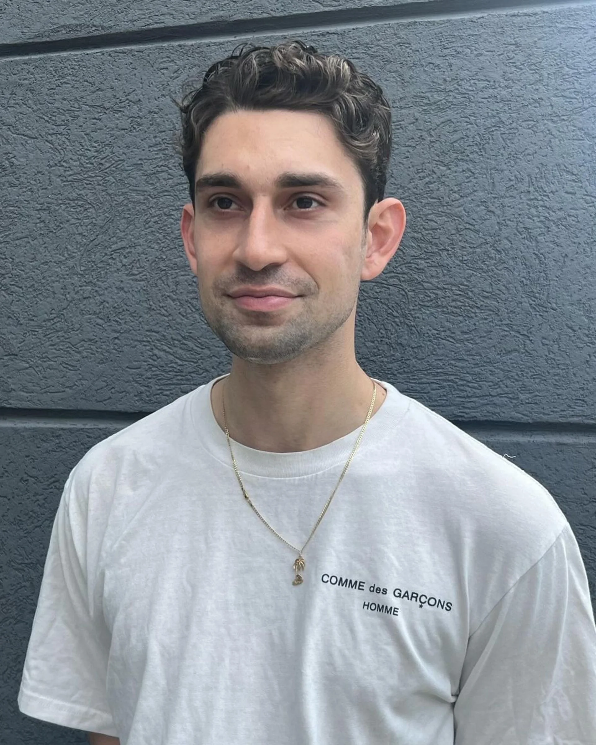 A man with a voluminous wavy pompadour, demonstrating a stylish cut that adds height and covers the hairline. - Preview 2