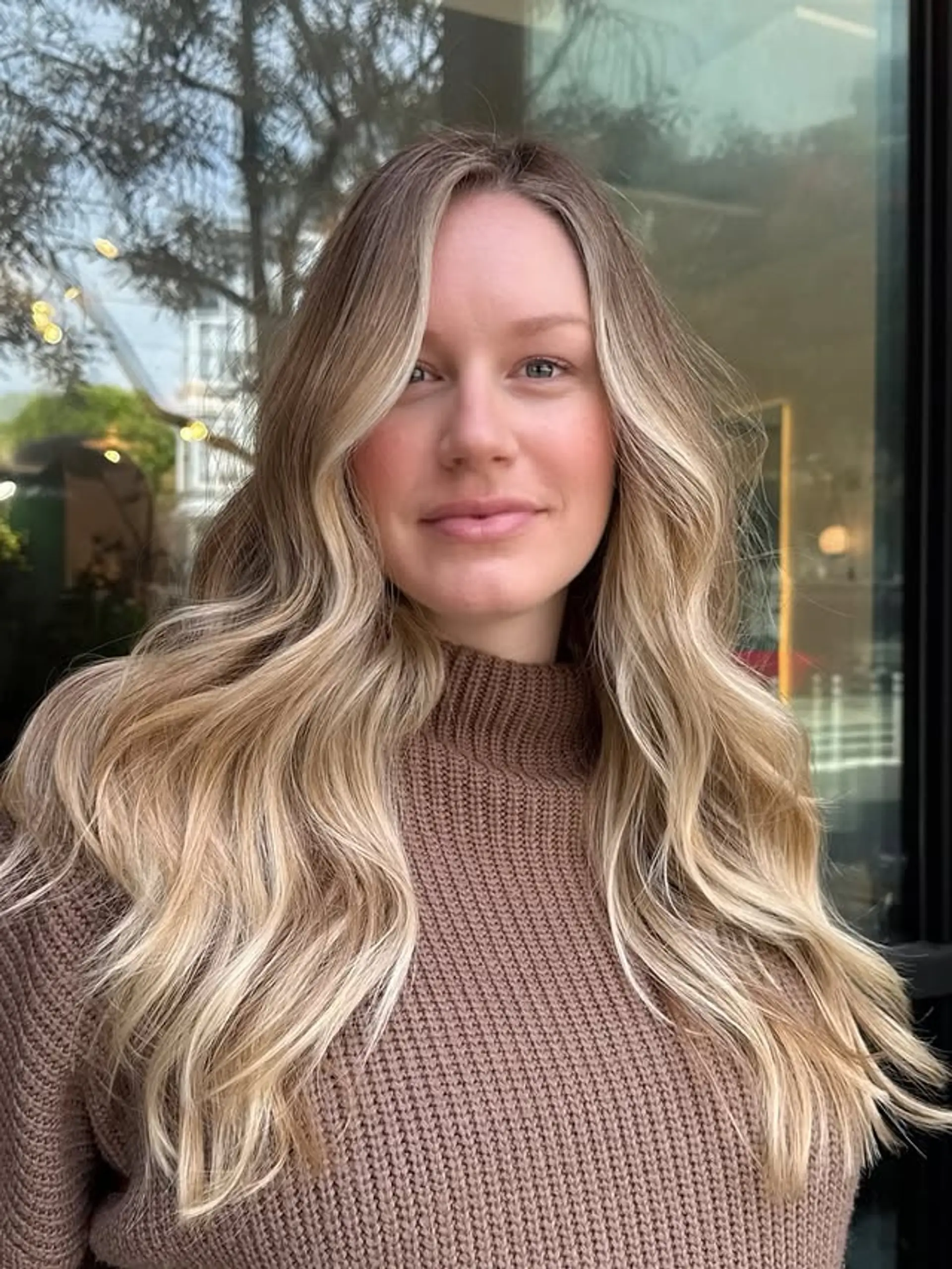 Long, wavy hair with a blonde balayage and loose beachy waves. 1