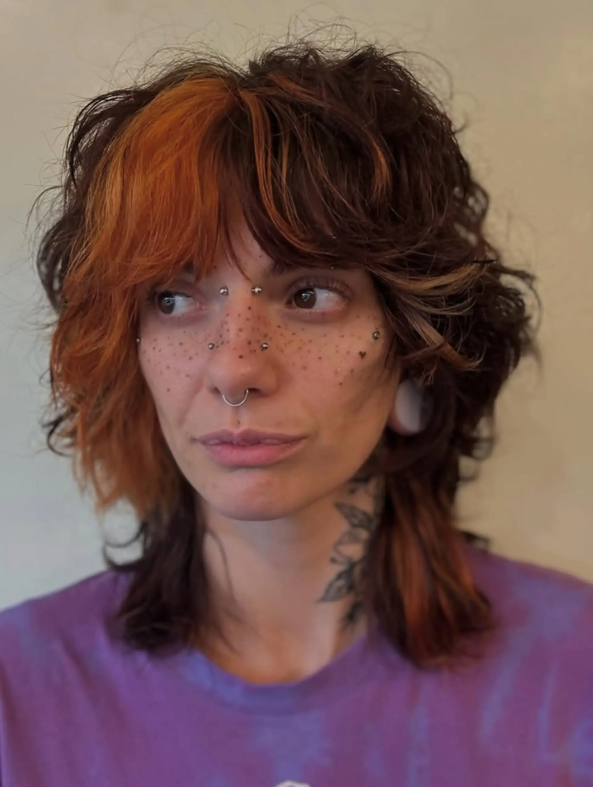 A medium-length textured shag mullet featuring choppy, face-framing layers and a bold copper-orange fringe section. 1