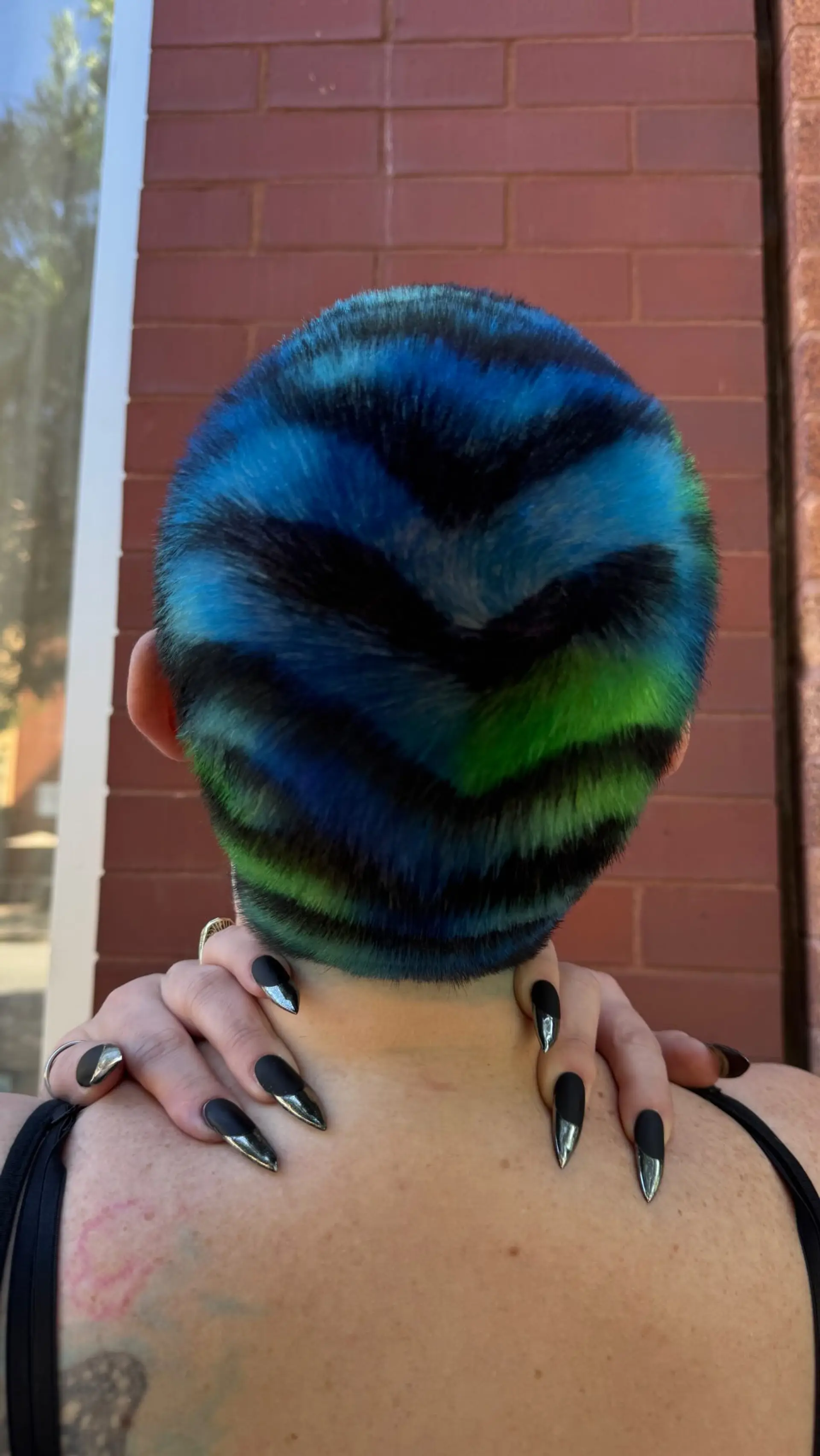 A buzz cut featuring a hand-painted chevron pattern in electric blue, bright green, and black. 1