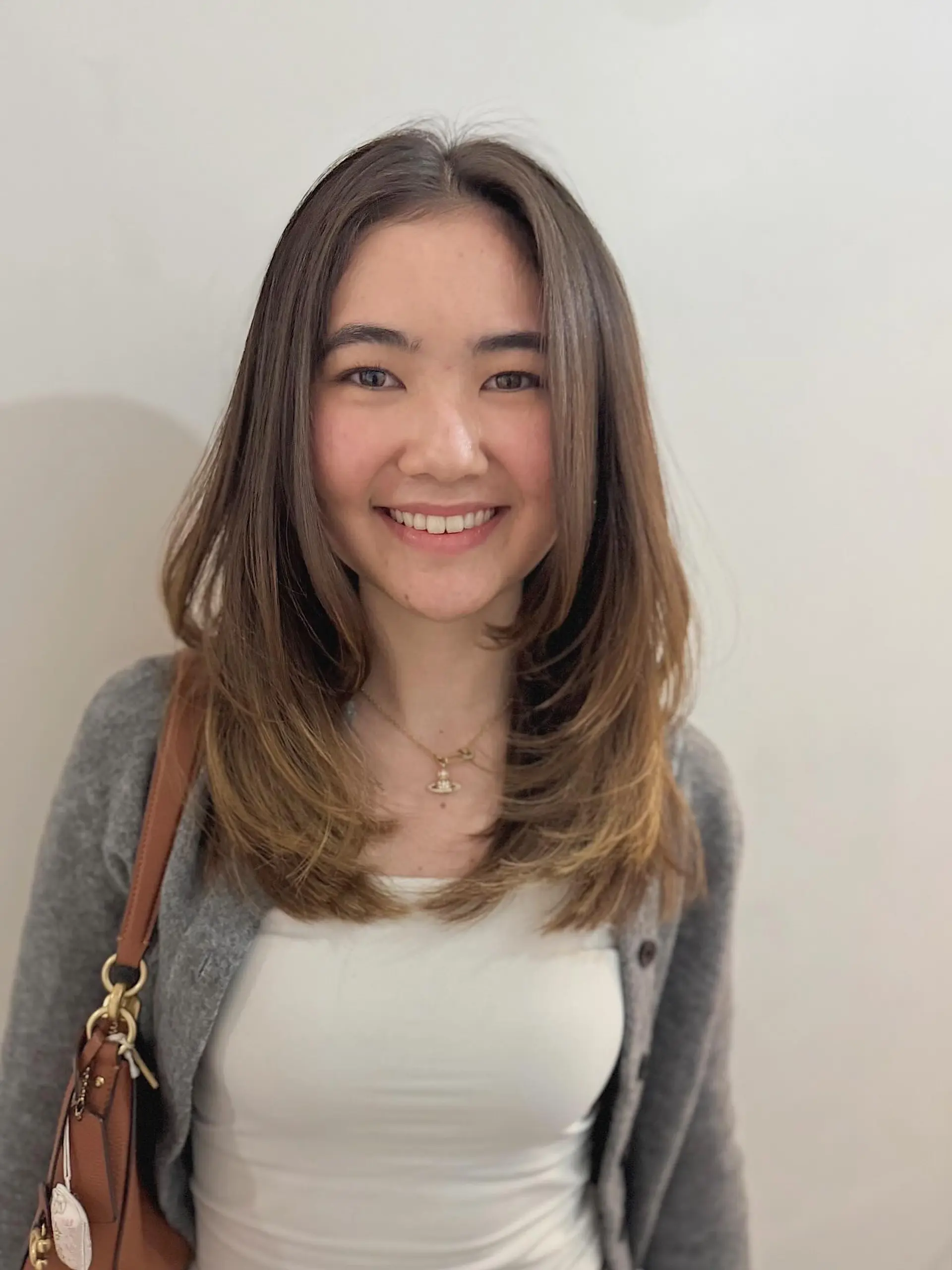 This style features long, soft layers throughout, with distinct face-framing layers that create movement and volume. The length falls past the collarbone, creating a flattering and versatile look. 1