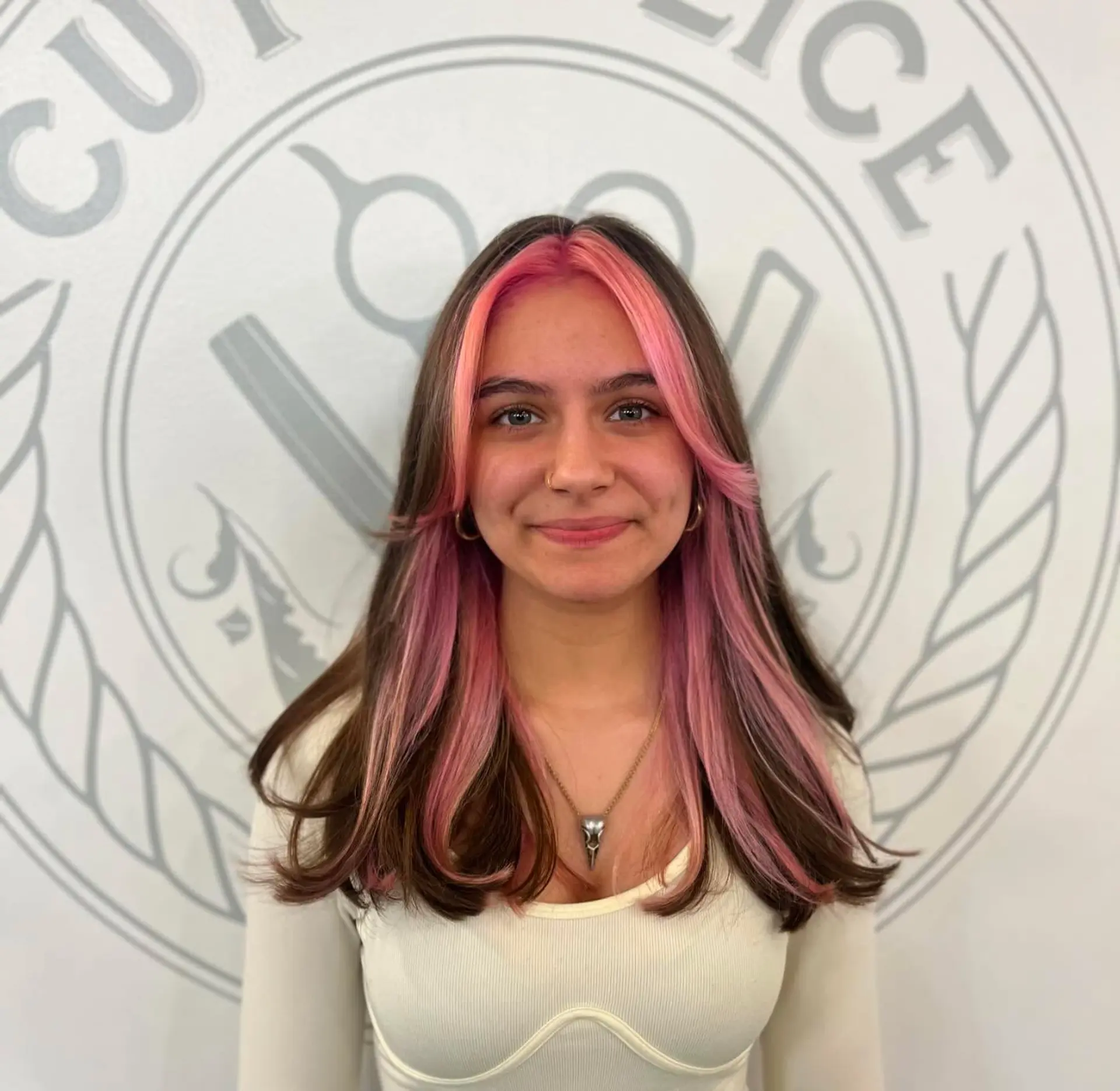 Medium-to-long brunette hair featuring a vibrant bubblegum pink money piece framing the face, paired with curtain bangs and soft flipped ends. 1