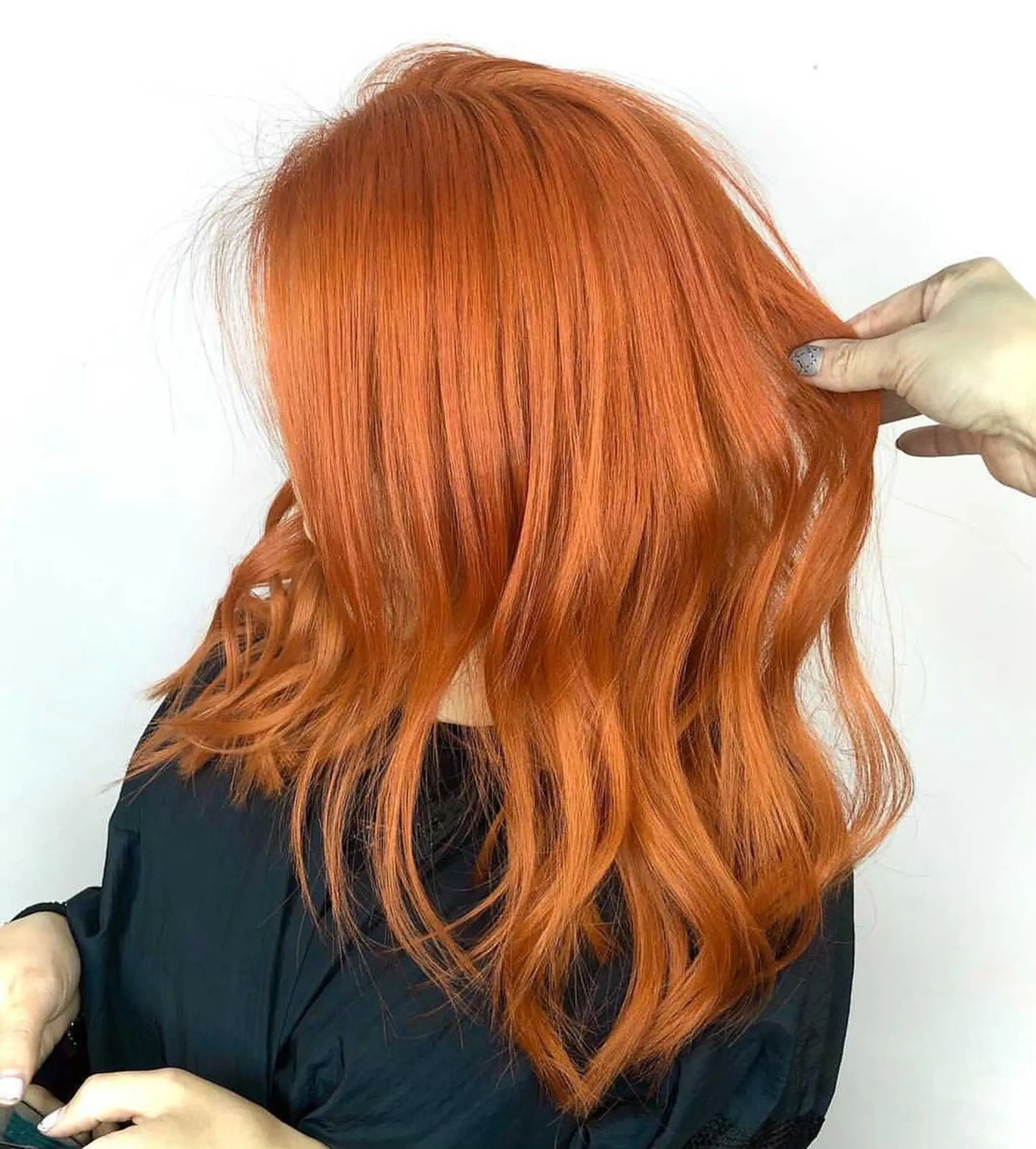 Features vibrant orange hair with copper highlights, medium length, wavy texture, and a layered cut that adds movement and dimension, with soft waves cascading down.
Stylist - @xcellent_jason