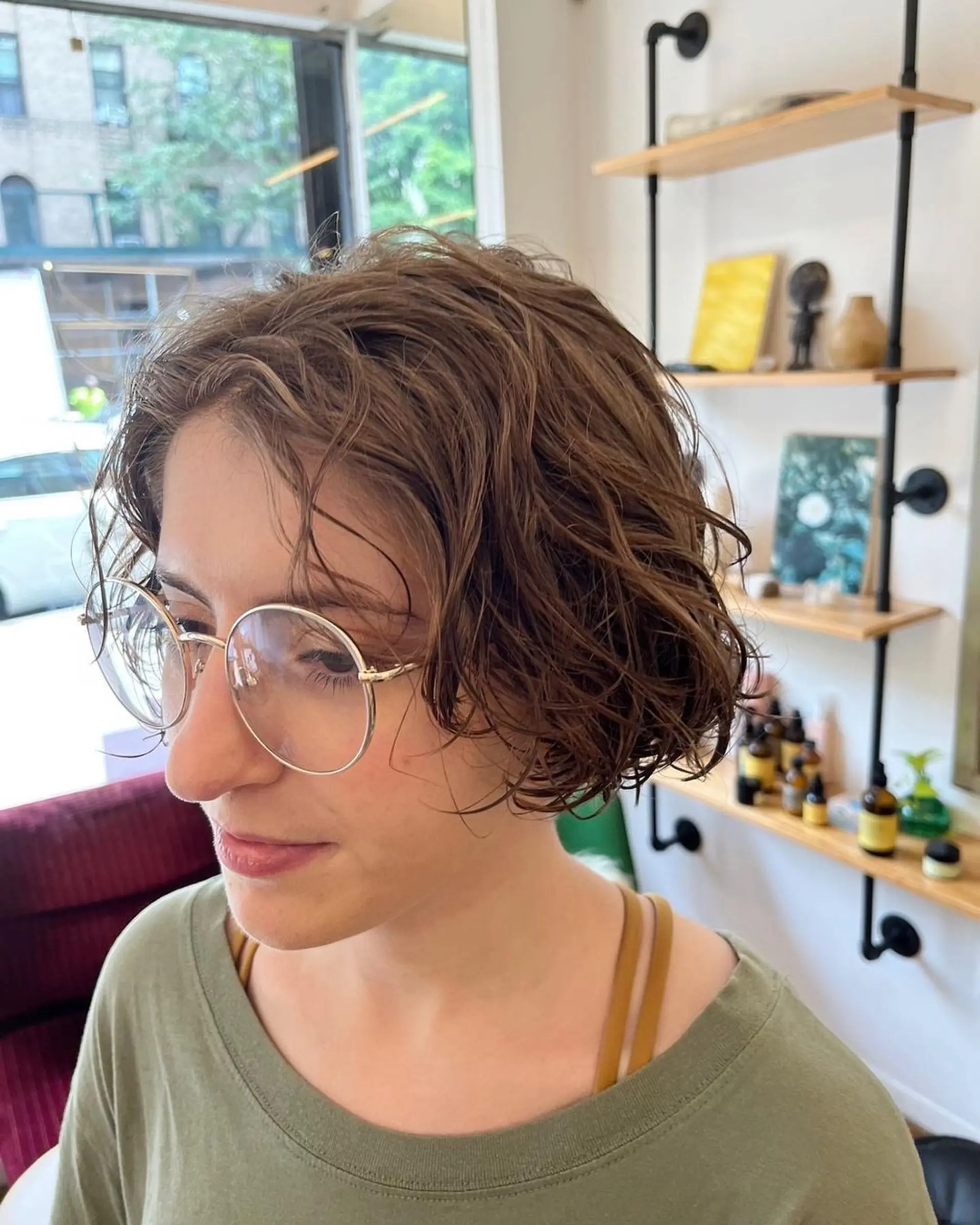 A short, light brown wavy bob with layers creating a tousled, textured look. Perm and Hair cut by @limi.nyc 1
