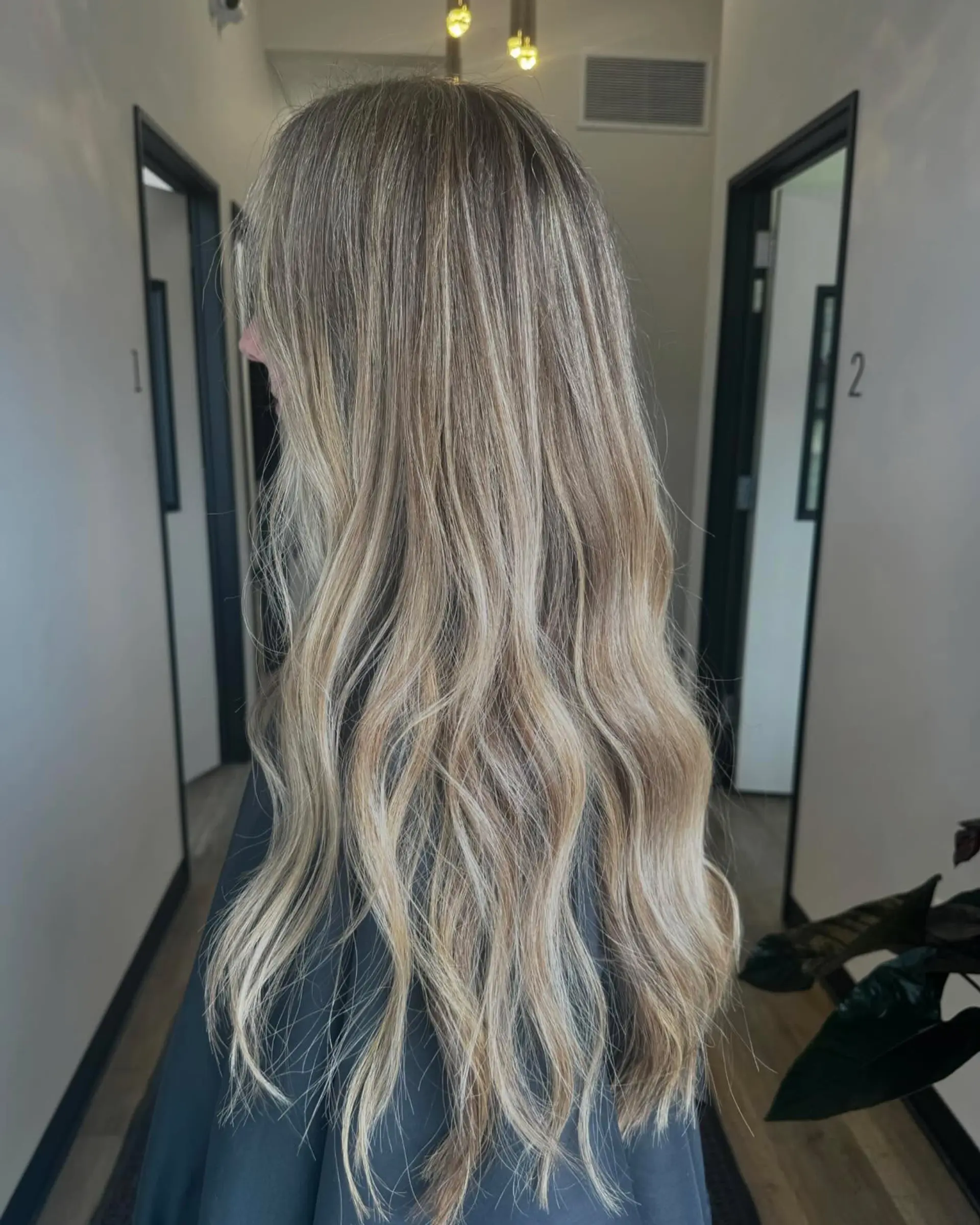 Long hair featuring seamless dimensional blonde highlights styled with loose, relaxed waves. 1