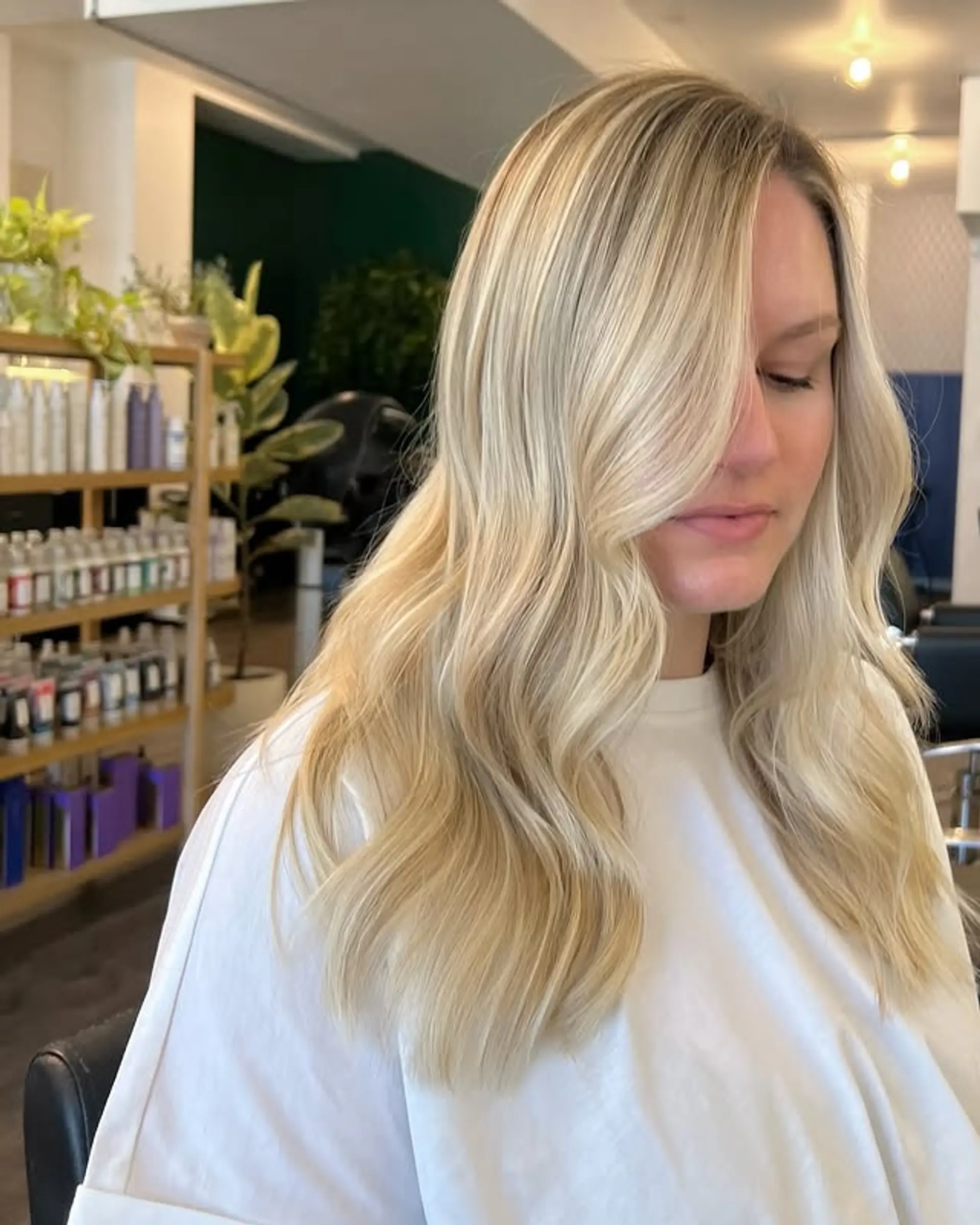 Long wavy hair with blonde balayage, styled into beachy waves with face-framing layers. 1