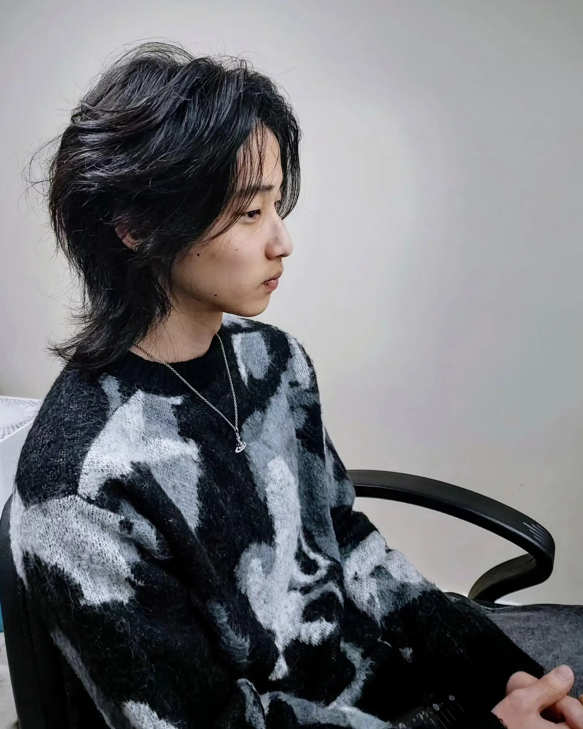 A medium-length textured wolf cut featuring soft, feathered layers and flowing curtain fringe. 1