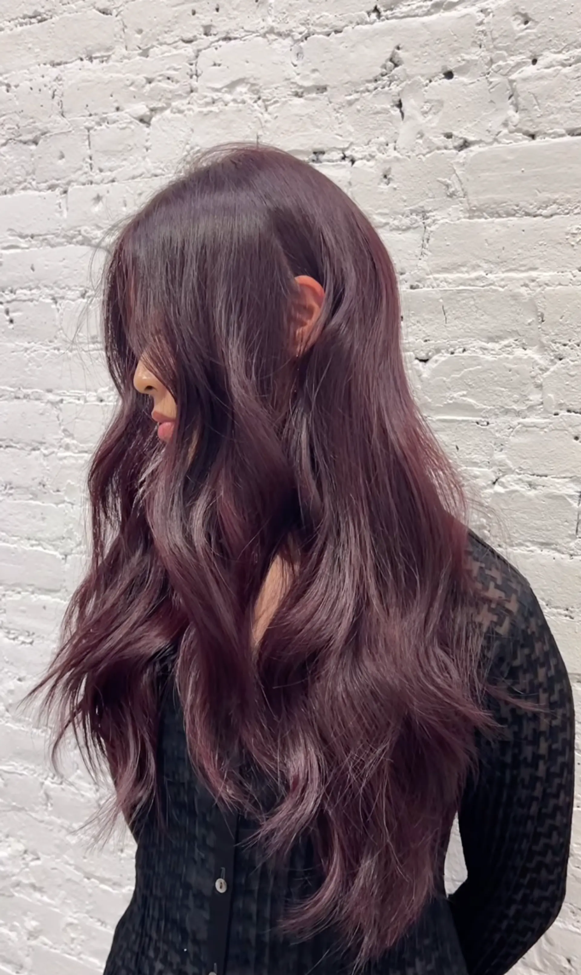 Long, wavy hair in a deep mahogany shade with side-swept bangs and voluminous layers. 1
