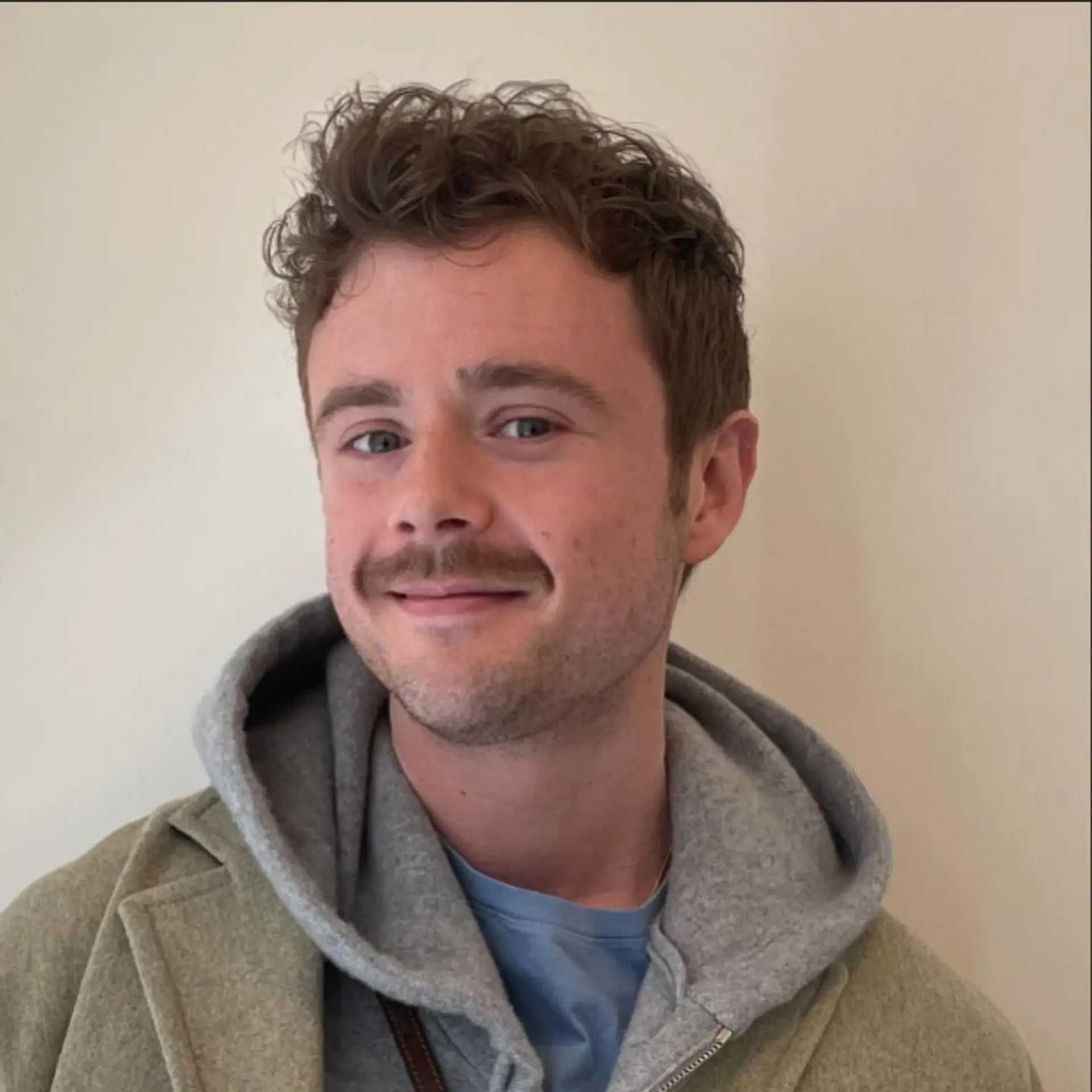 A short, curly hairstyle with a textured top and neatly trimmed sides, showcasing natural curls in a casual yet refined manner. 1