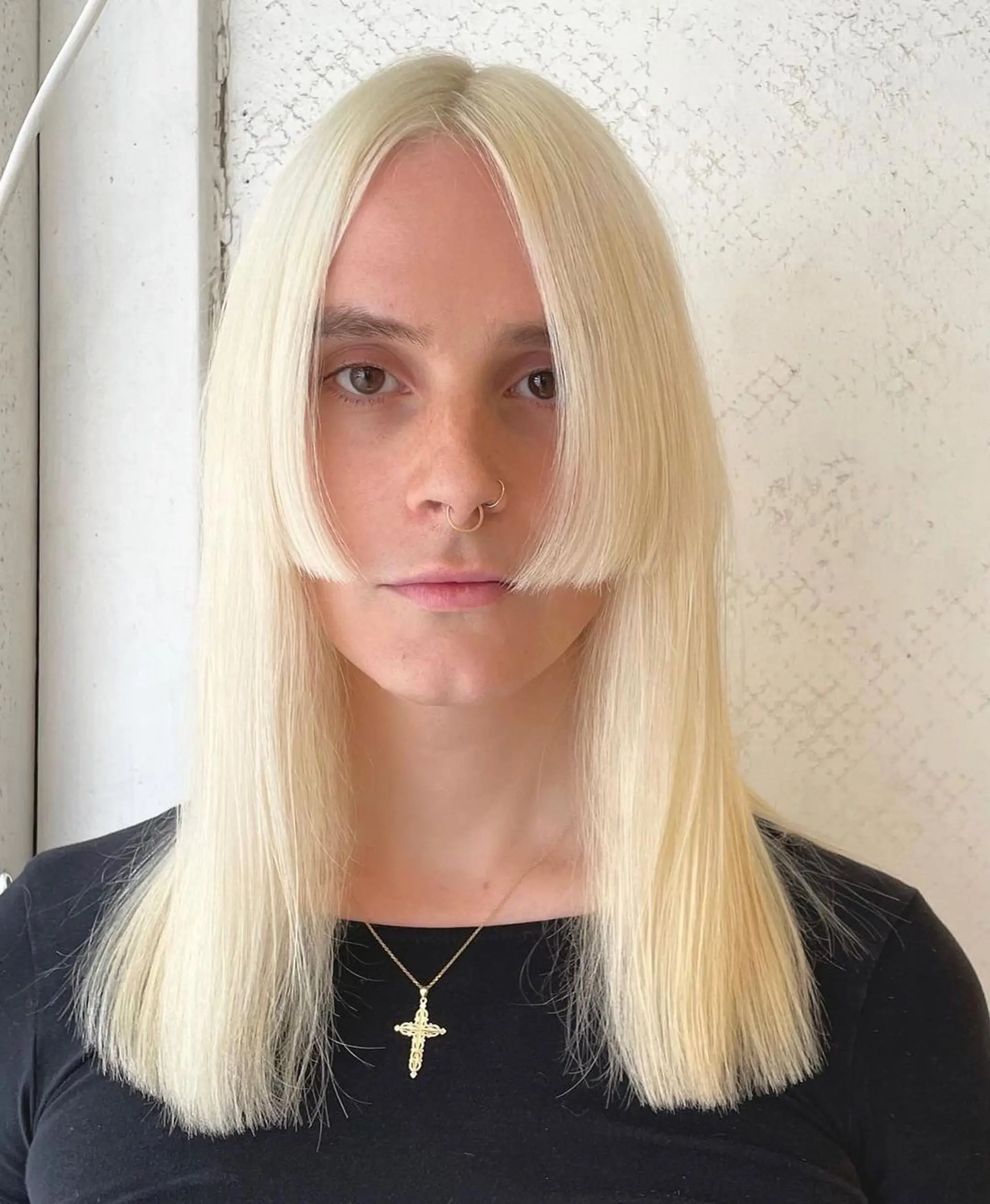 A long, sleek platinum blonde hairstyle with blunt bangs and a center part, offering a smooth, curtain-like effect. 2