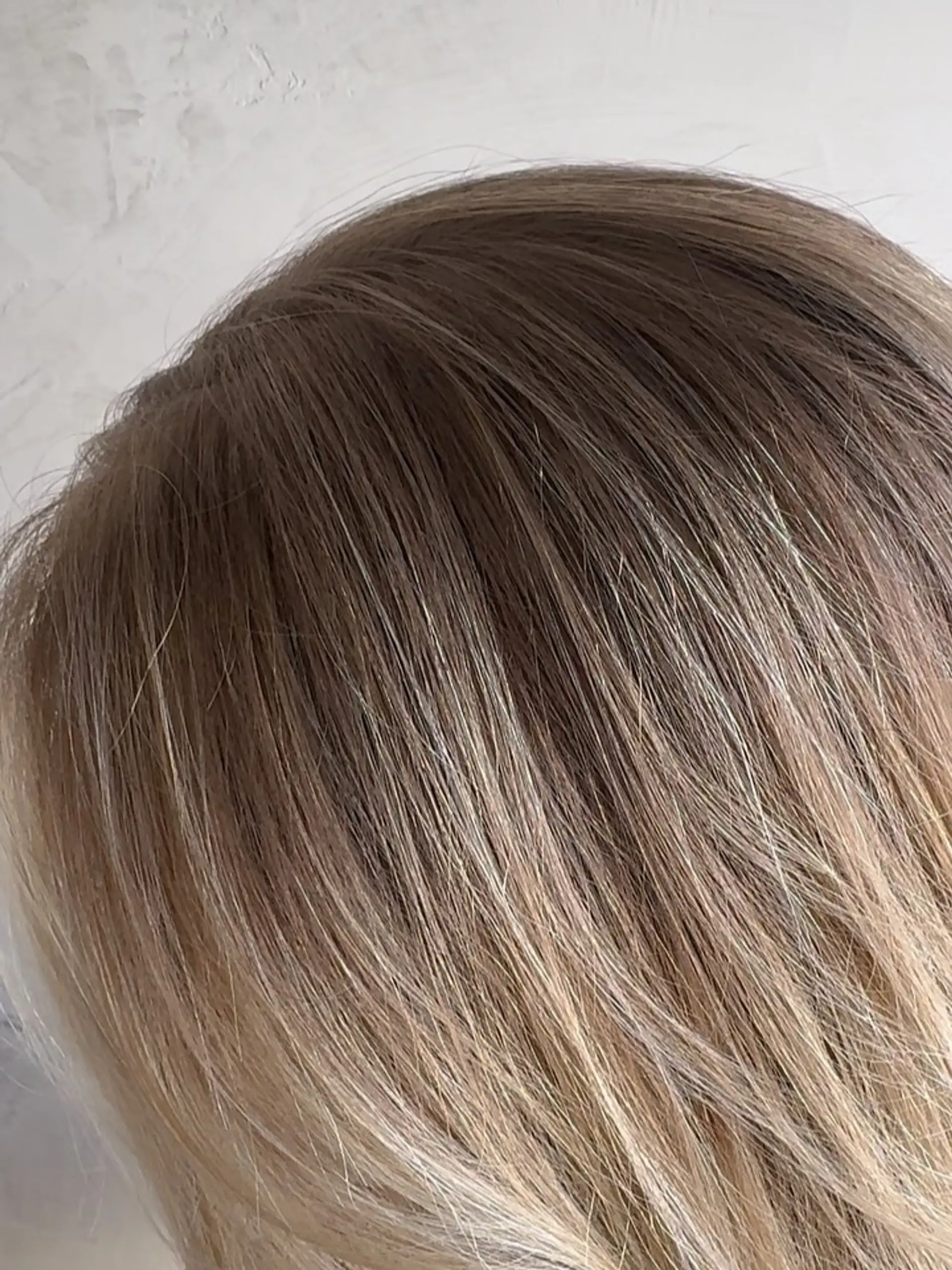 A close-up shot of finely blended blonde babylights seamlessly integrated into a soft, natural base. 1