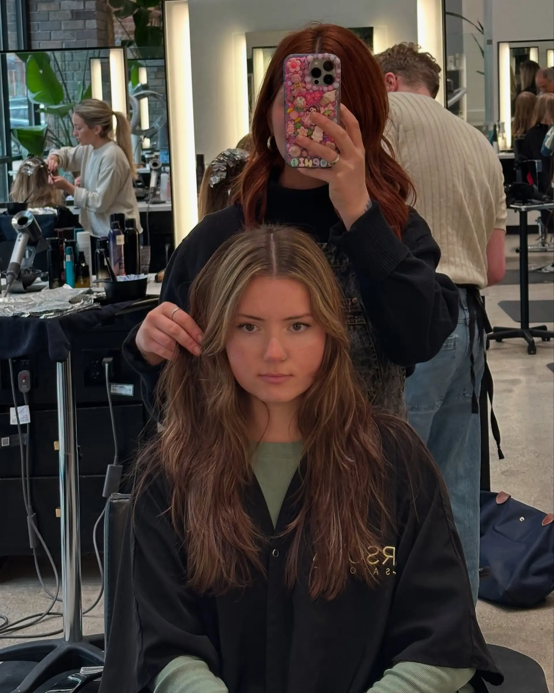 Long layered haircut with face-framing bangs and subtle red highlights. 2