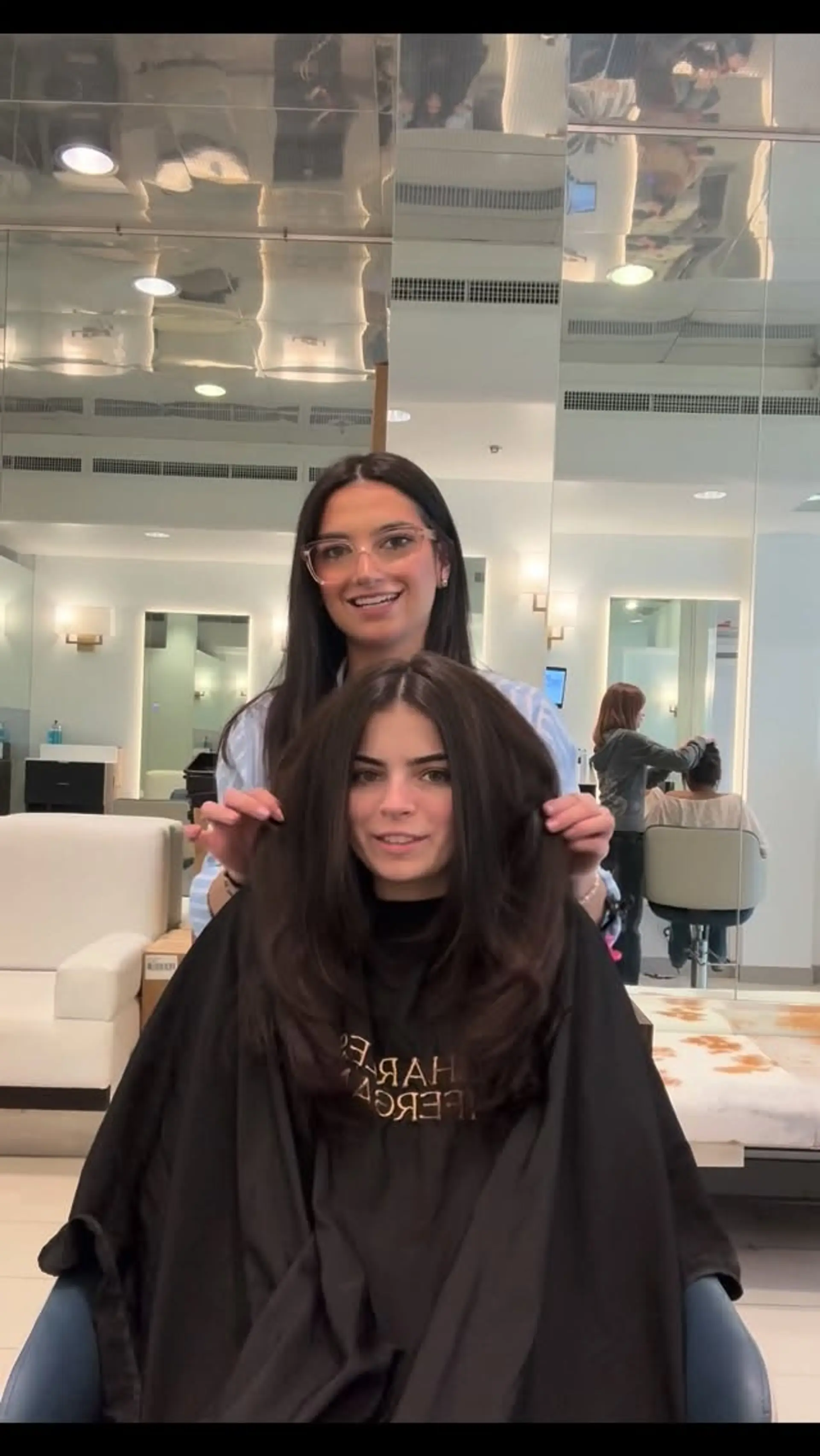 Medium-length dark brunette haircut with face-framing layers and a bouncy, rounded blowout. 1