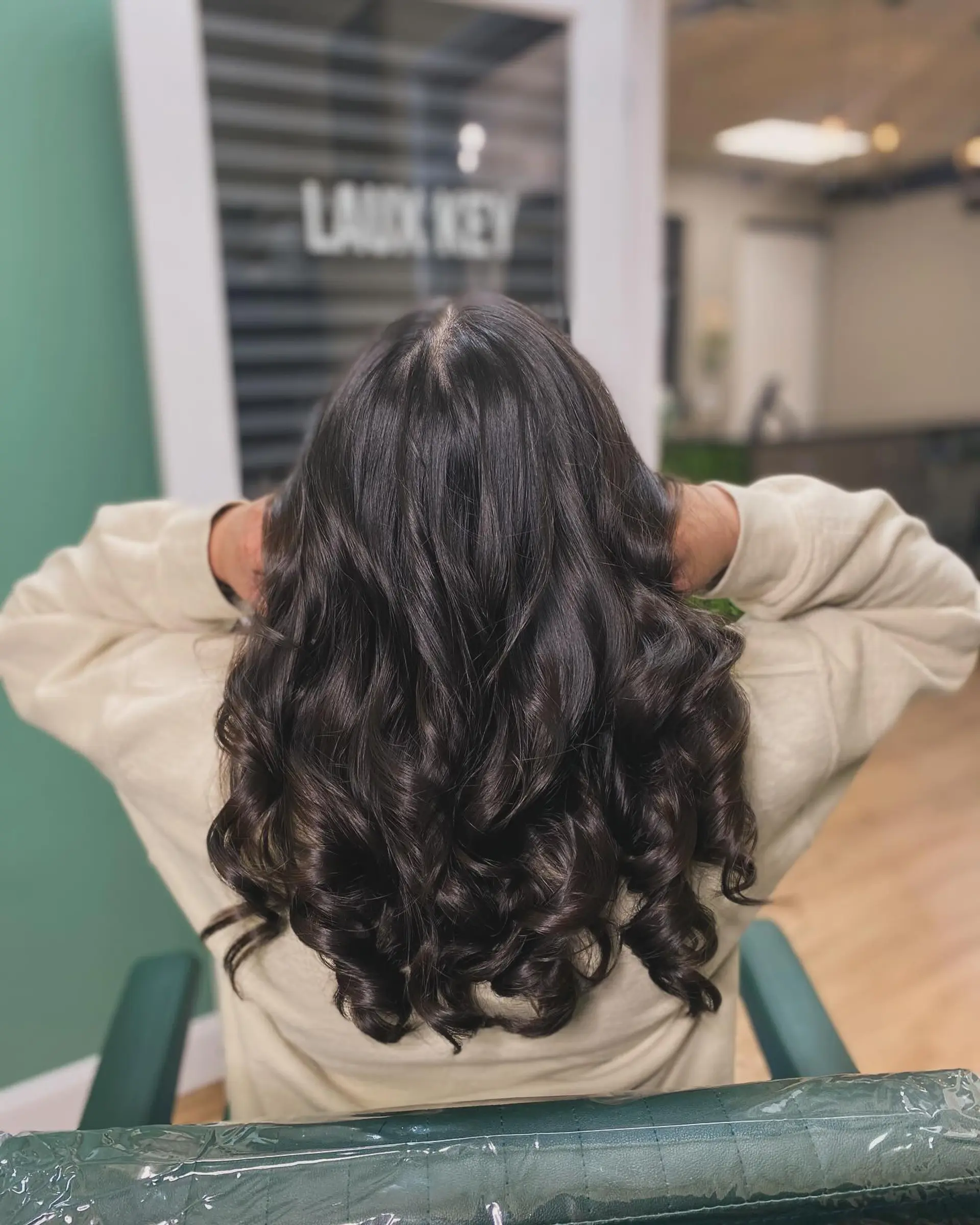 A sleek, glossy silk press styled with luscious, defined spiral curls concentrated at the ends. 1