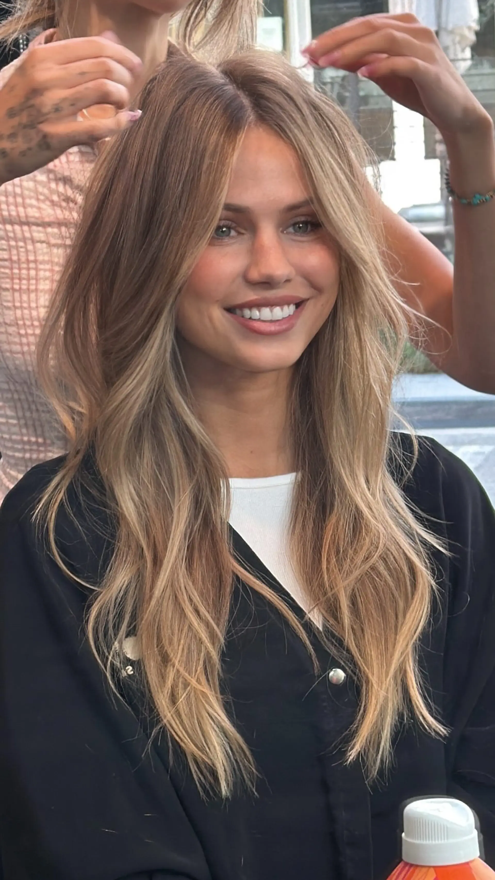 Long dimensional honey blonde hair with natural root melt, soft face-framing curtain layers, and gentle textured waves. 1