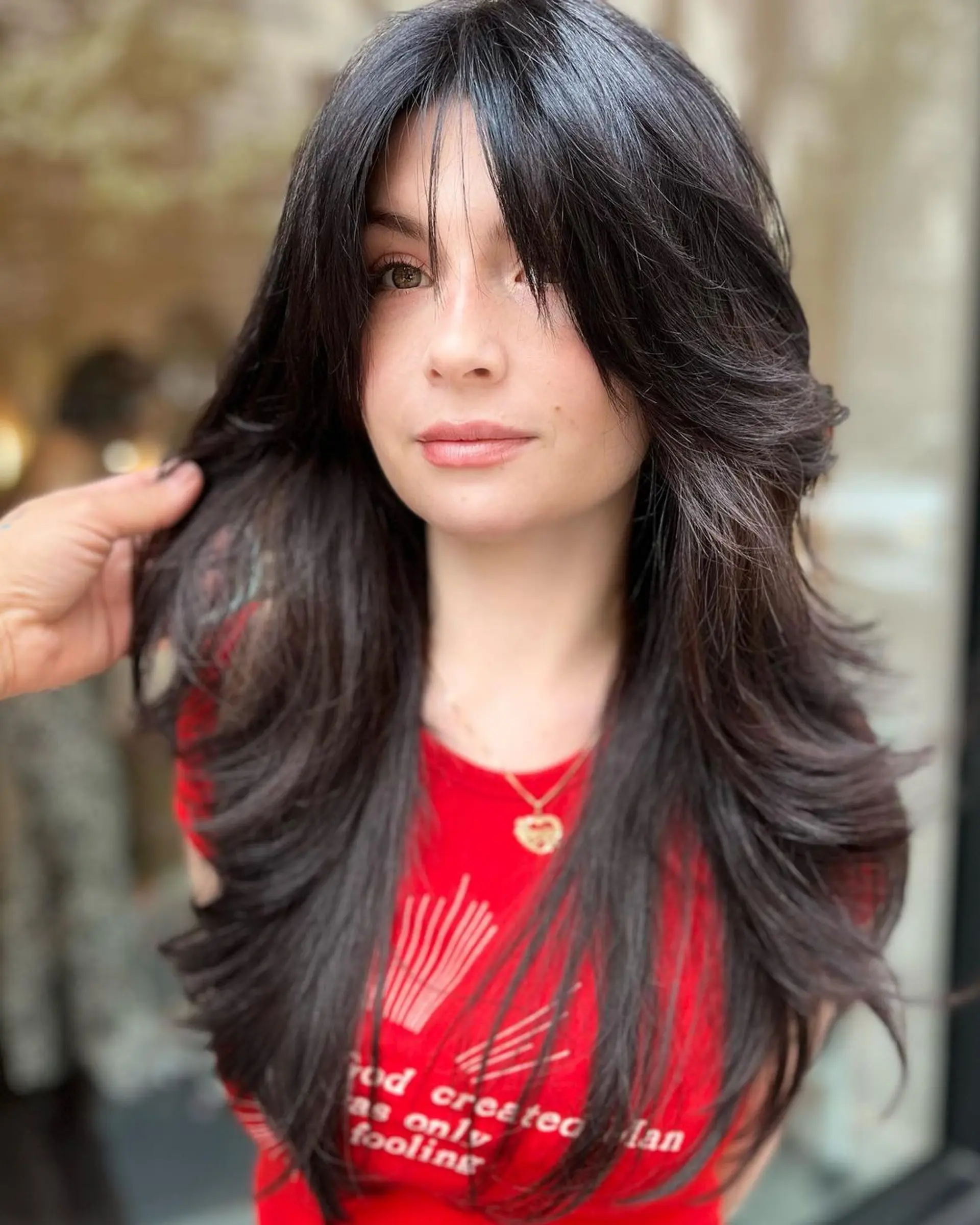 Long, straight, black hair with a lustrous finish, layered ends, and side-swept locks. 1