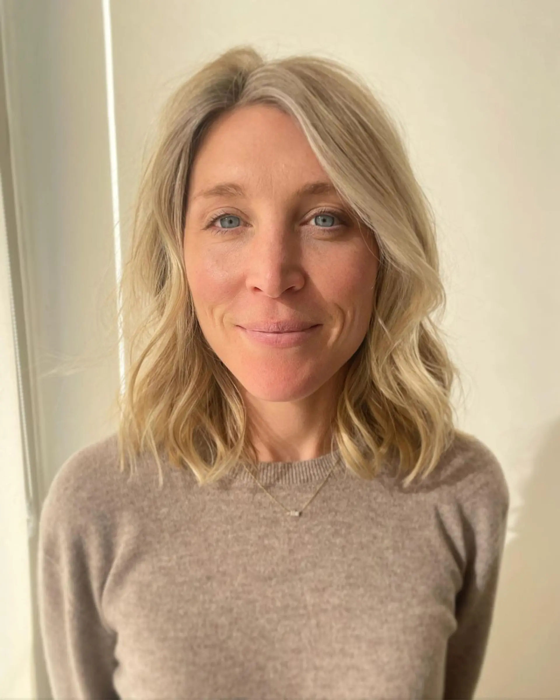 Medium-length wavy hair with soft waves and natural volume, blonde with platinum highlights, and a face-framing layered structure. 1