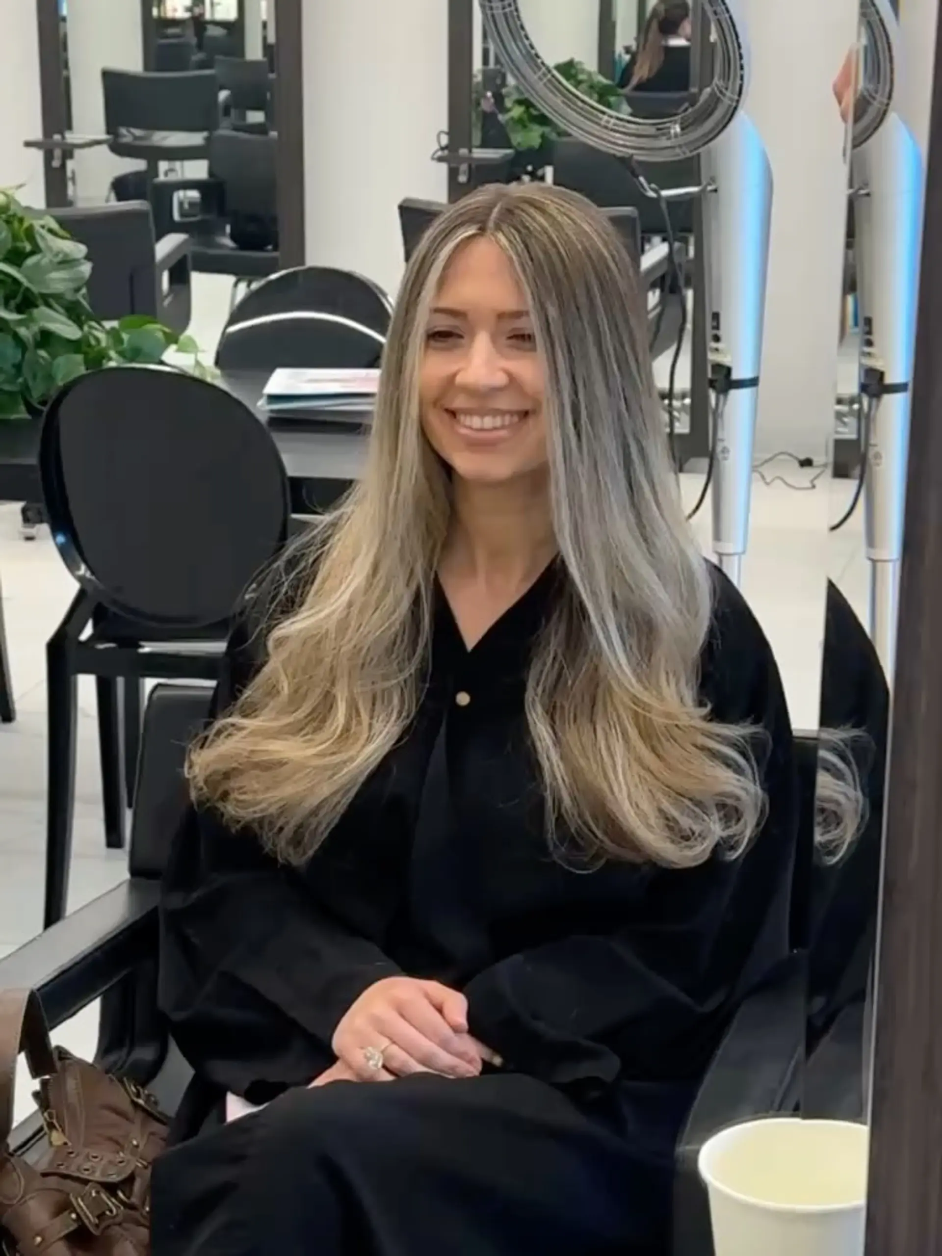 Long, flowing ash blonde hair styled with a center part, brighter face-framing highlights, and voluminous curled ends. 1