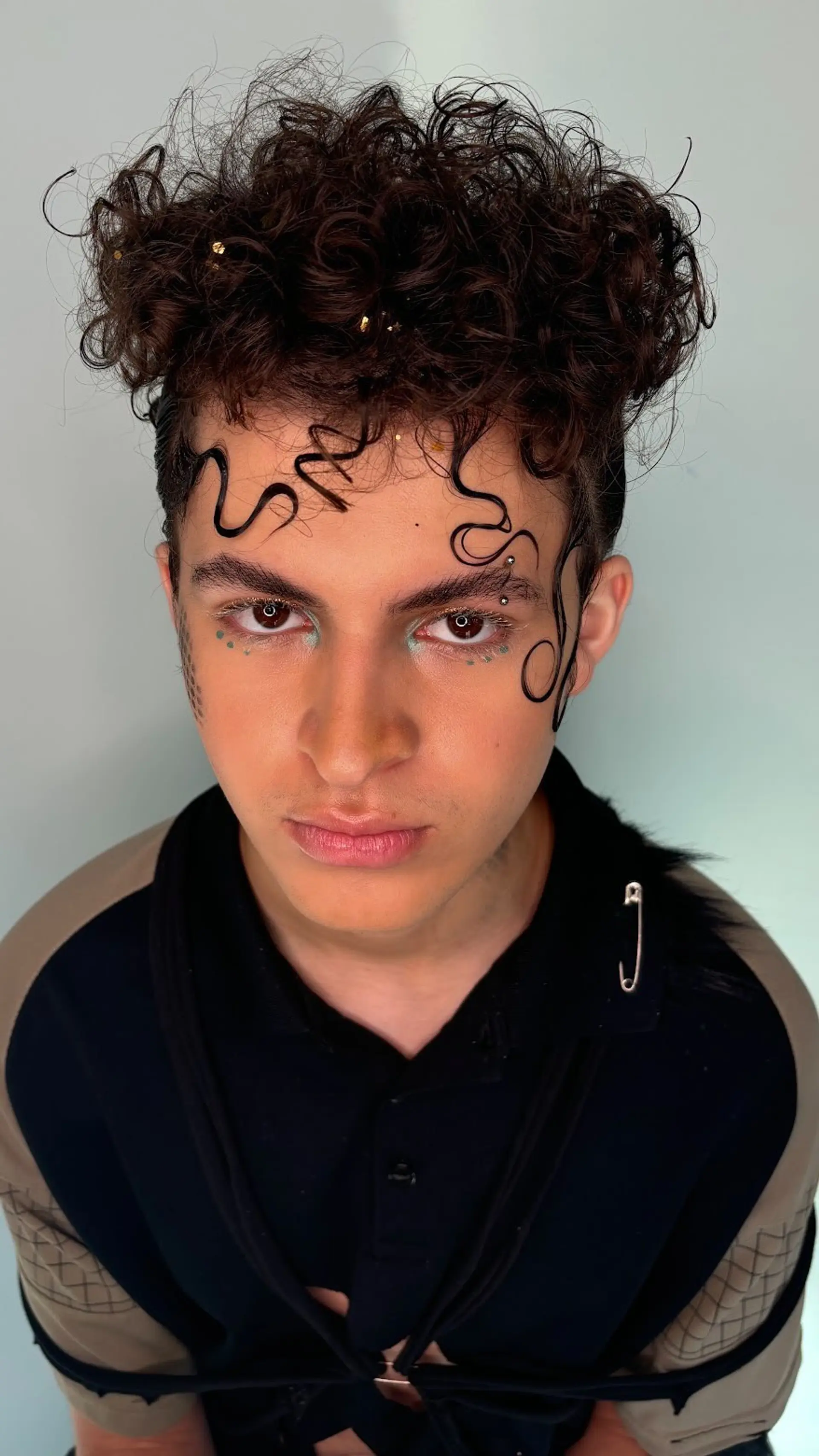 Editorial updo featuring voluminous defined curls on top and sleek, sculpted gel swirls across the forehead. 1