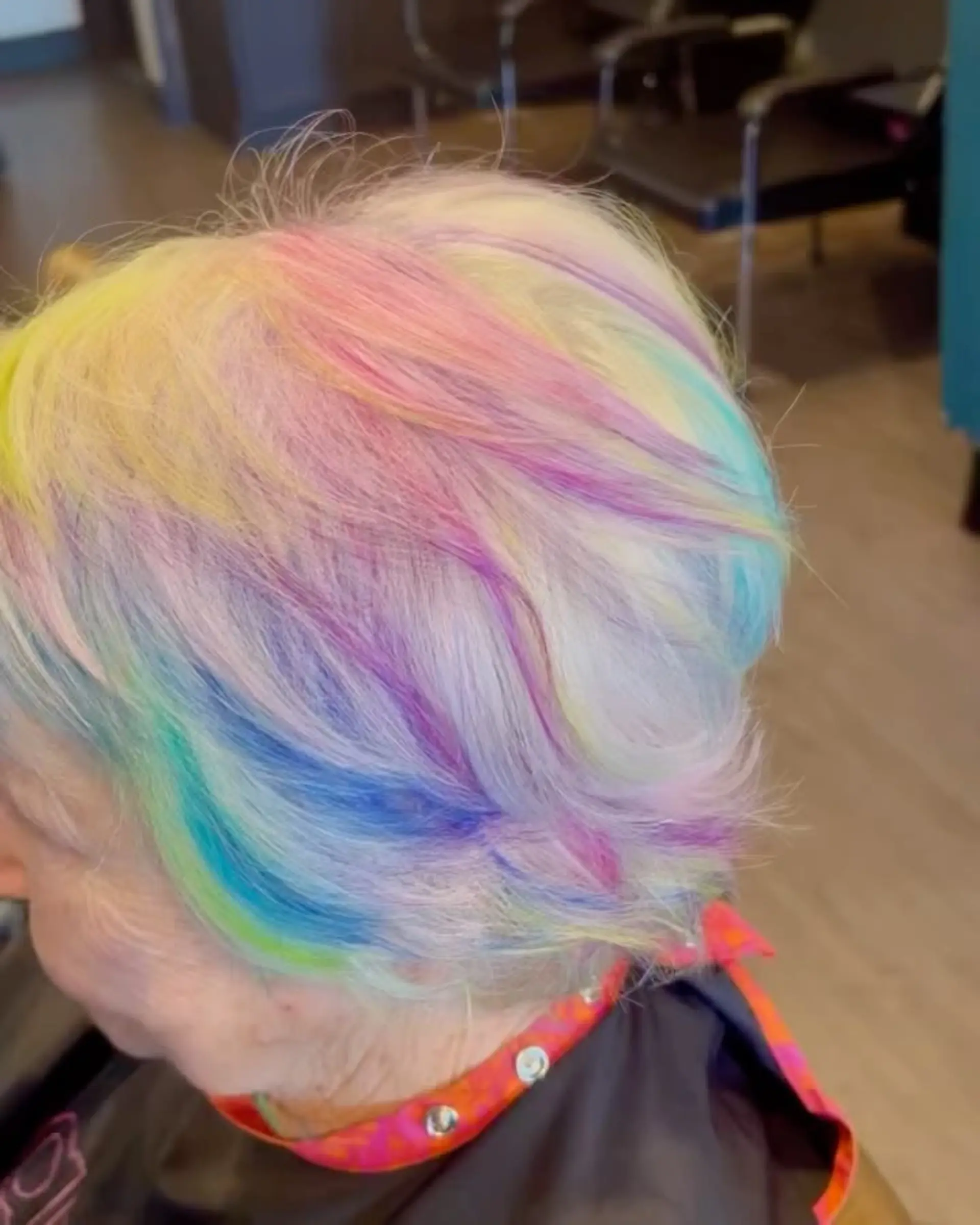 A layered, textured short crop styled with soft pastel rainbow tones painted across a light blonde base. 1