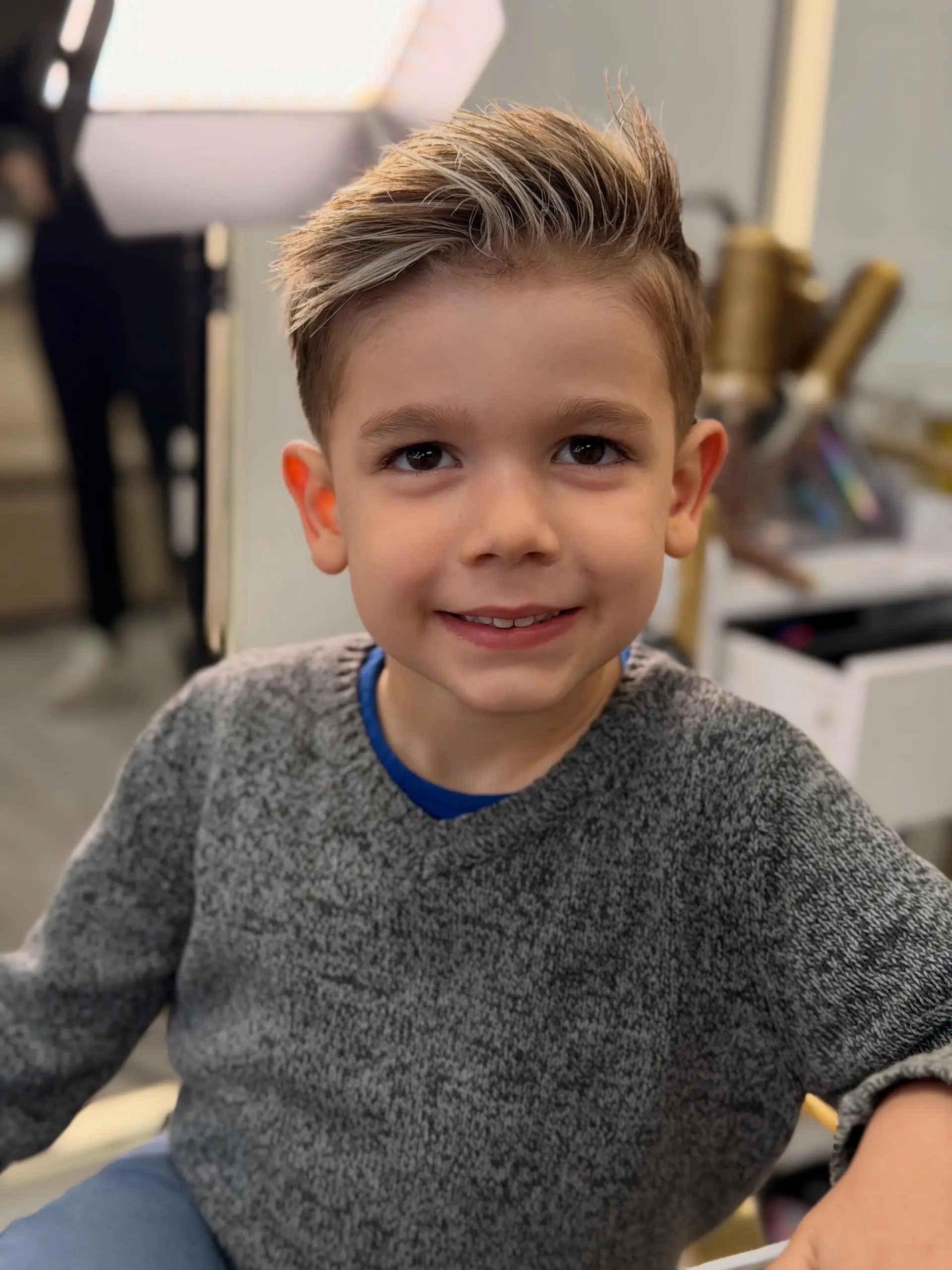 A clean short boys' haircut featuring neatly tapered sides and a textured, side-swept top. 1