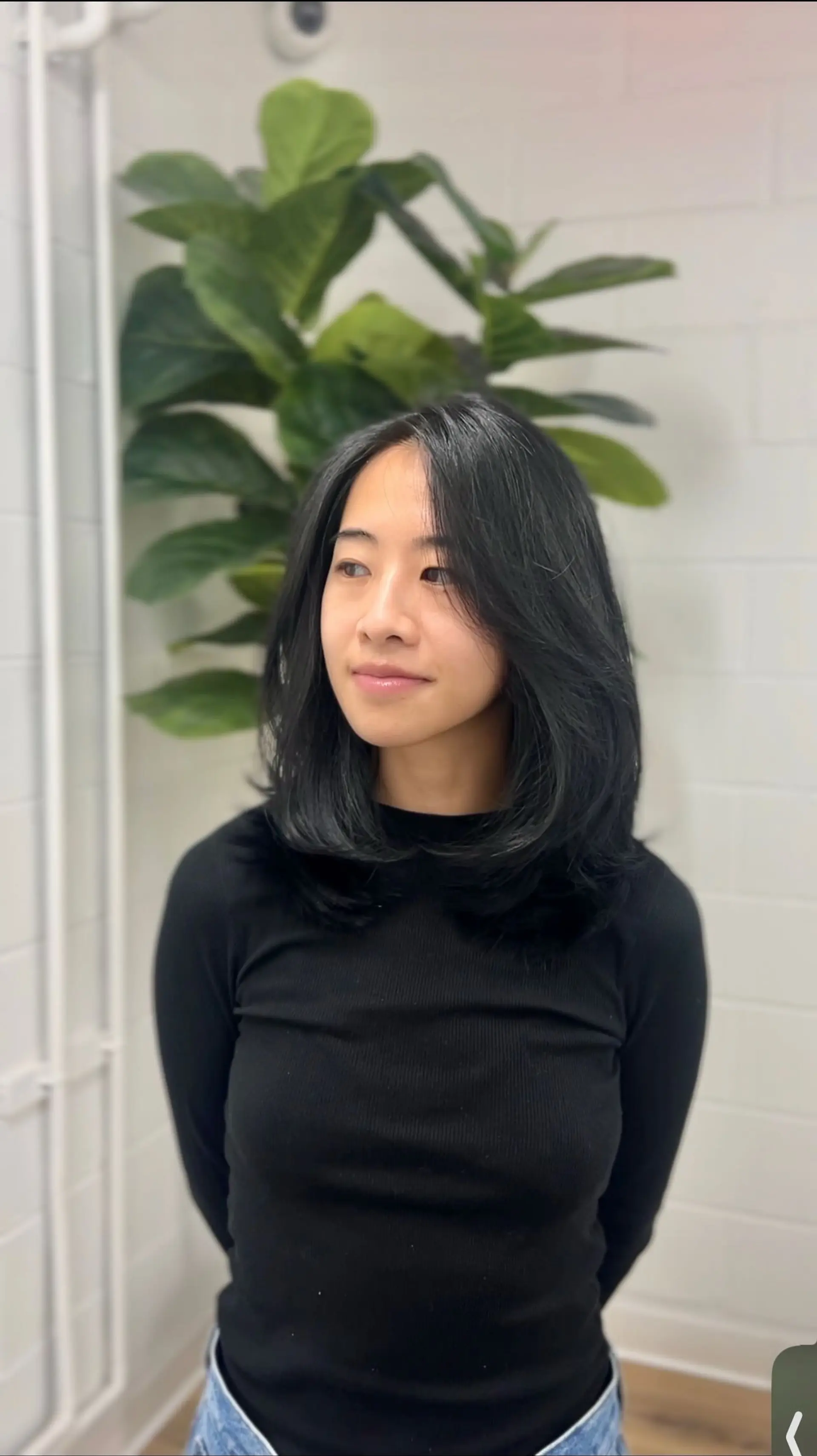 A medium-length layered haircut featuring face-framing curtain bangs and softly rounded ends. 1