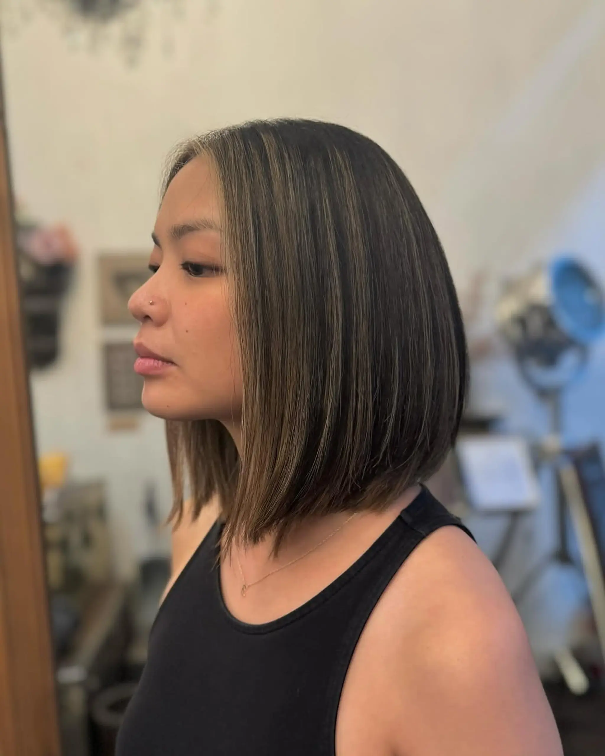 A medium-length, straight bob with blunt ends and honey blonde highlights on dark brown hair, creating a sleek and warm-toned look. 2