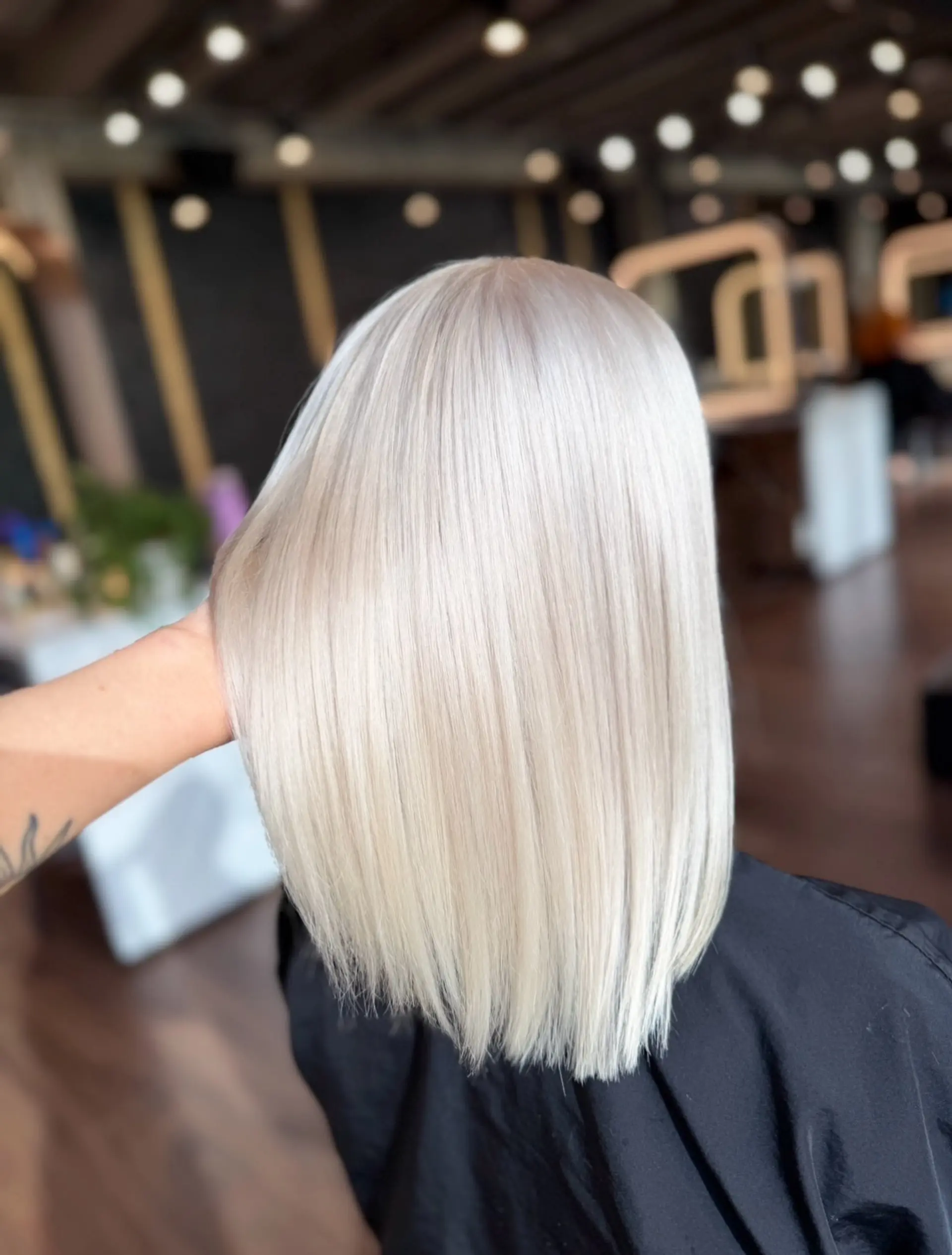 A sleek, shoulder-length blunt cut styled straight in an ultra-light, solid platinum blonde shade. 1
