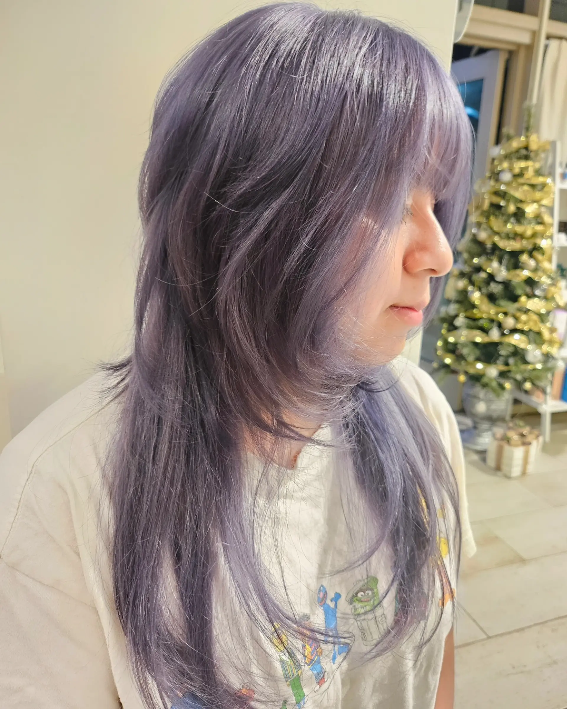 Long, heavily layered wolf cut with full face-framing fringe in a cool ash lavender tone. 1