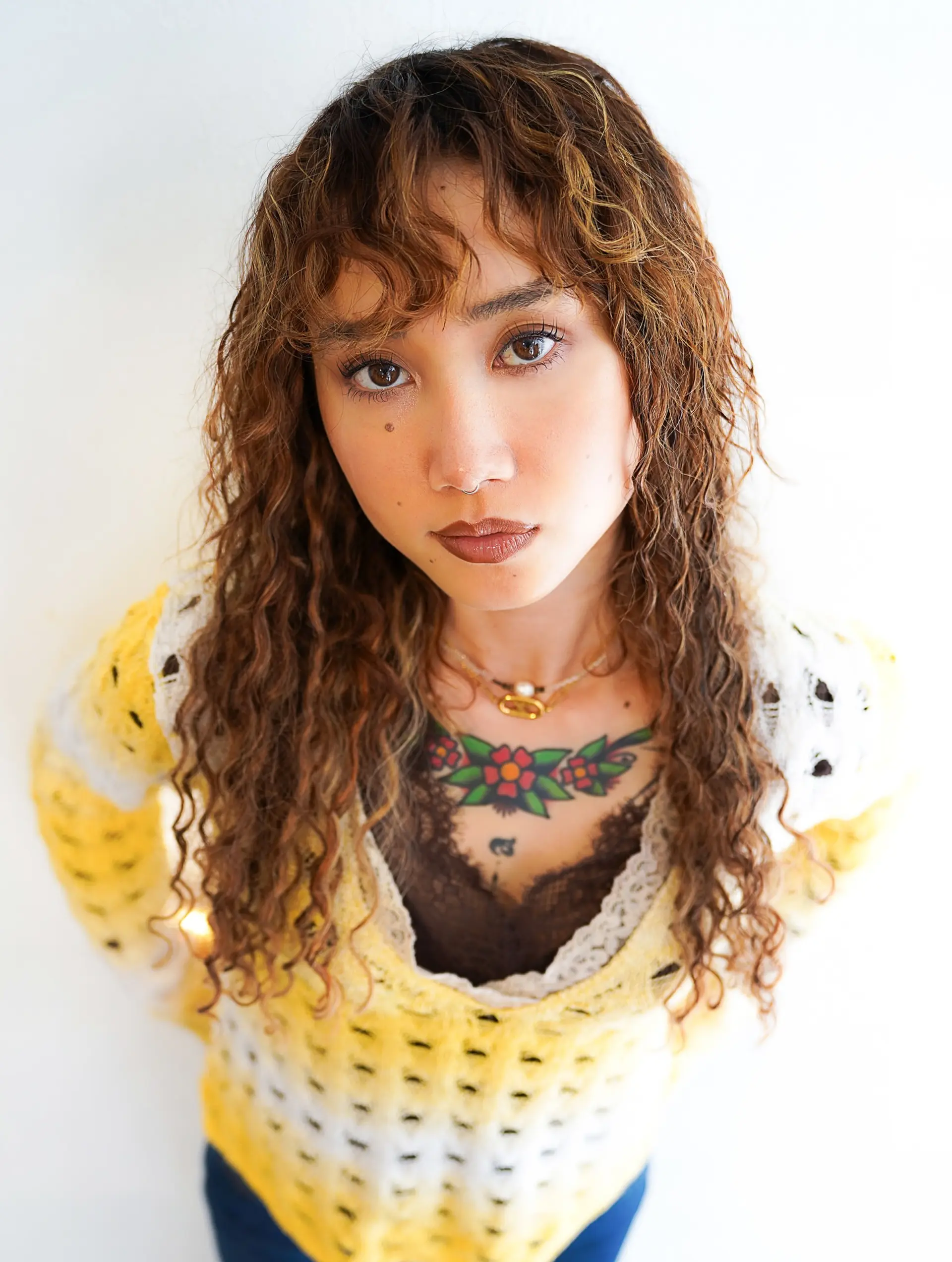 A textured curly shag cut featuring defined spiral waves, wispy curly bangs, and face-framing layers. 1