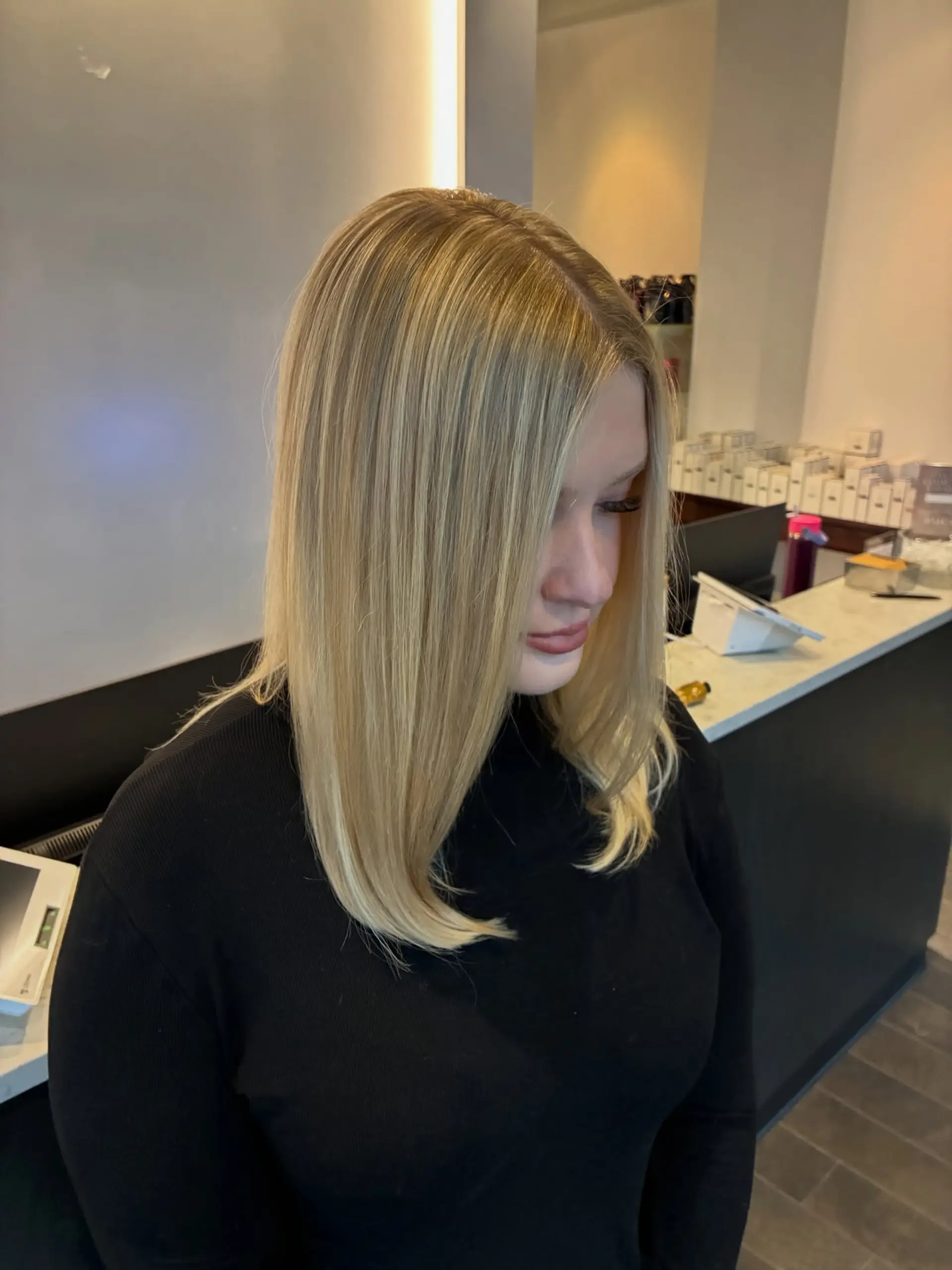 Sleek collarbone-length blonde lob styled straight with gently under-curled ends and seamless multi-tonal highlights. 1