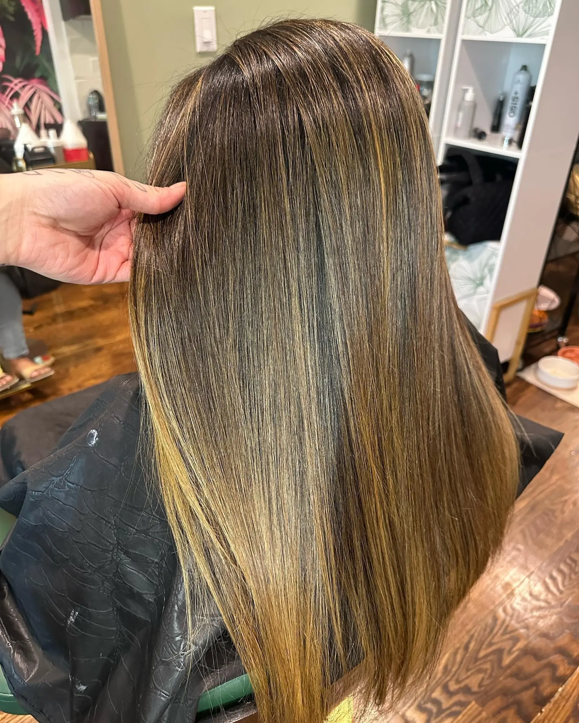 Long, sleek straight brunette hair illuminated with seamless caramel and warm golden balayage highlights. 1