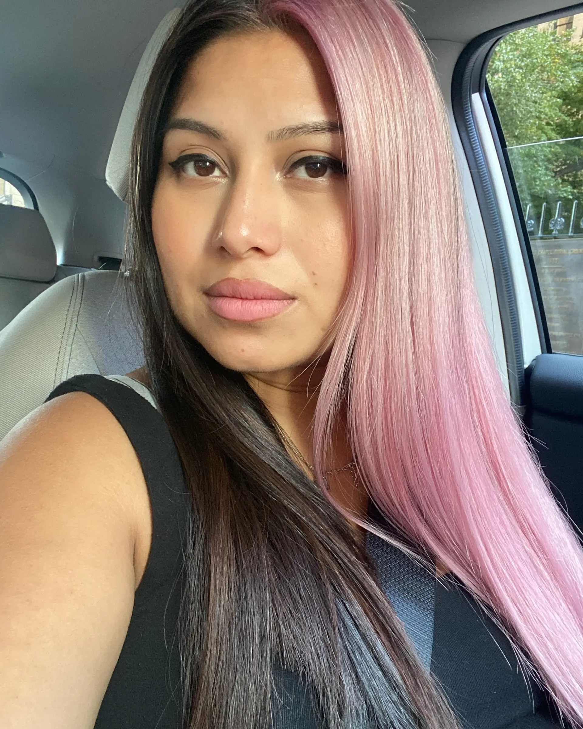 A dramatic split-dye hairstyle featuring one side colored in pastel bubblegum pink and the other in natural dark brown, styled sleek and straight. 1
