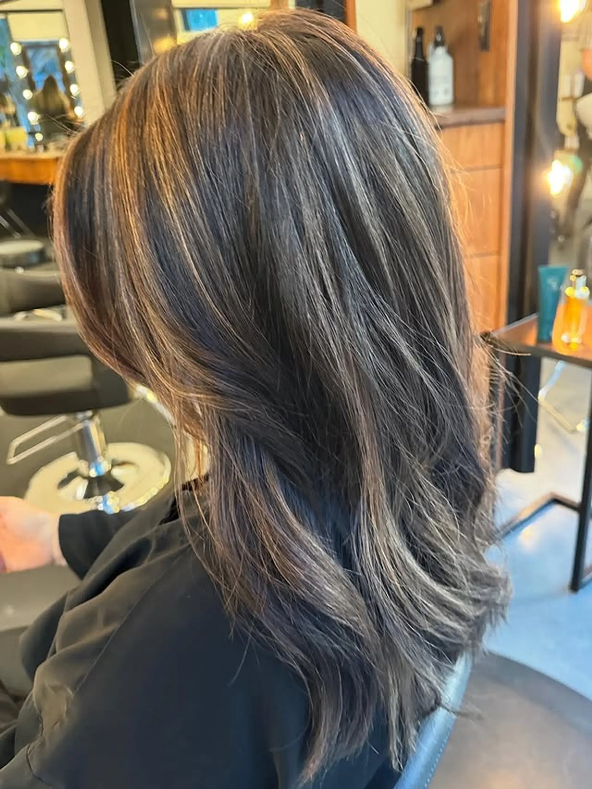 Wavy medium-length hair with a bronzed brunette balayage, layered ends, and face-framing. 1